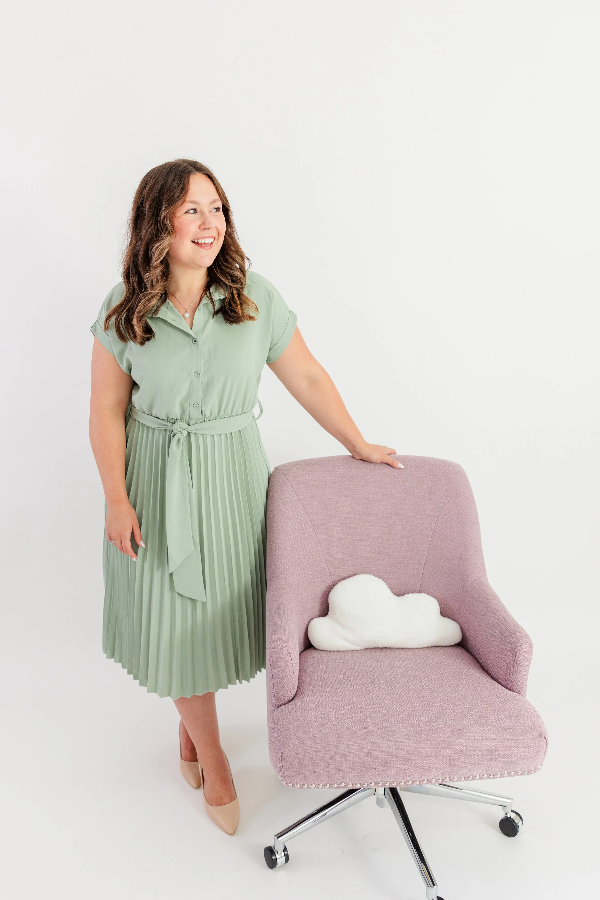 Woman in Green Pleated Dress with Pink Chair