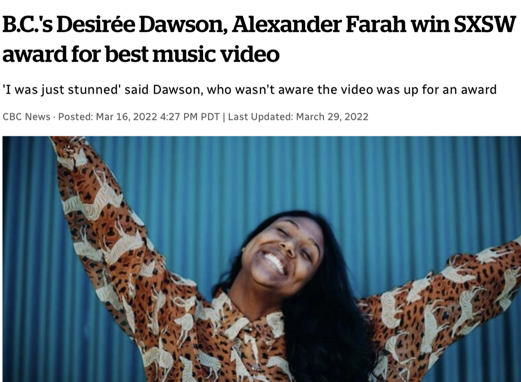 Desirée Dawson with dark hair, smiling joyfully, wearing a colorful animal print shirt, with a blue striped background