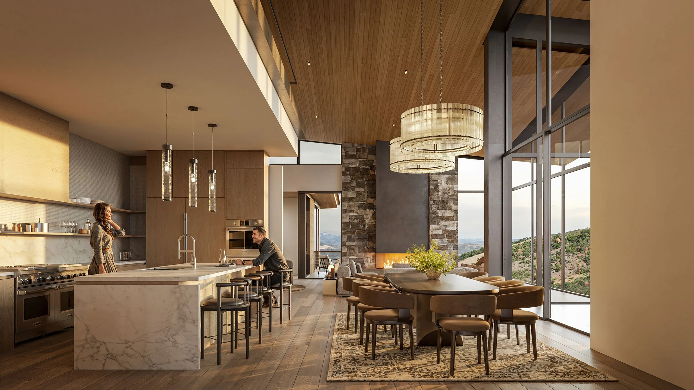 Open-concept kitchen and dining area with large windows overlooking hills, featuring a marble island, wooden cabinets, modern pendant lights, a fireplace, and around ten chairs around a long dining table with a floral centerpiece.