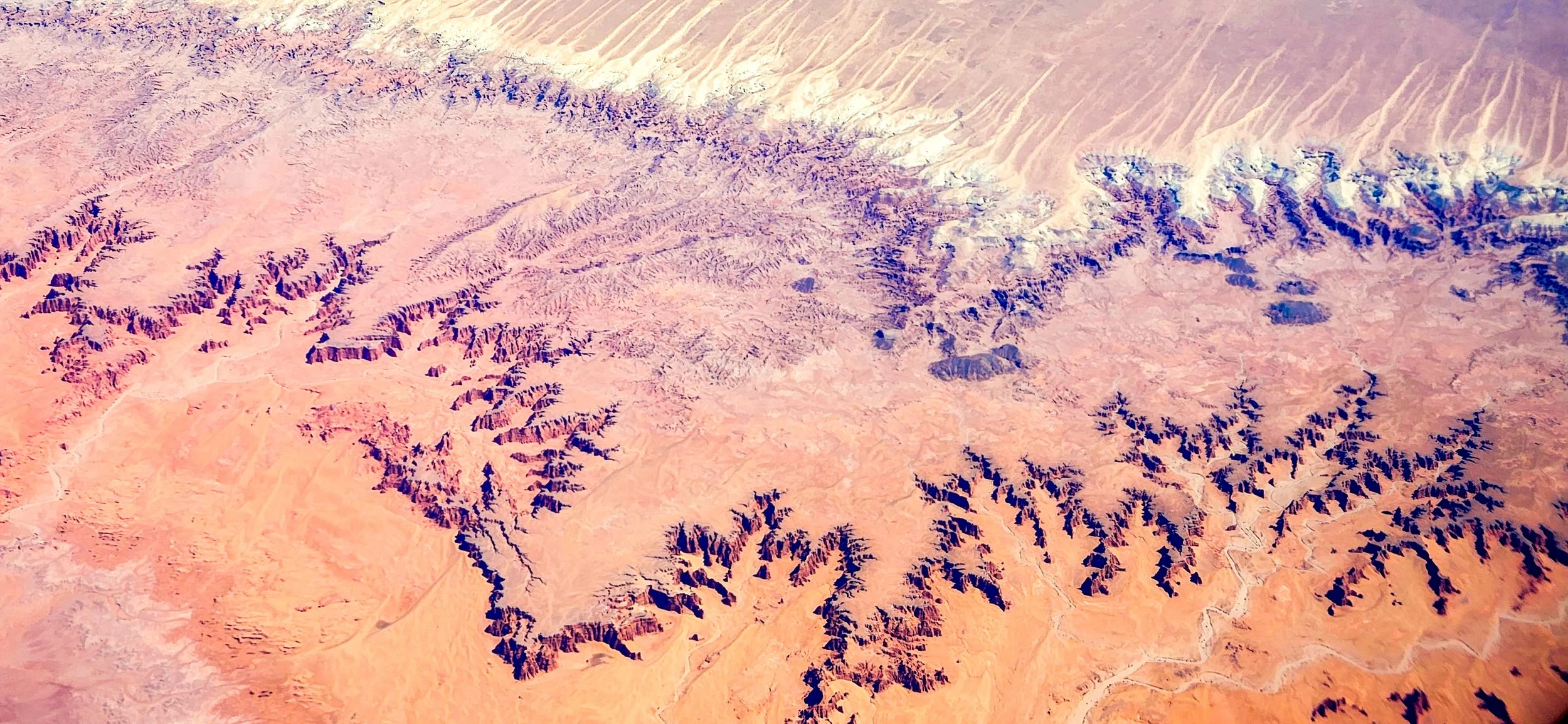 The Sands of Time
This top-down perspective captures the intricate, swirling patterns of coastal or desert dunes. The interplay of shadow and light emphasizes the ridgelines, creating a sense of fluid movement frozen in time. From this altitude, the 