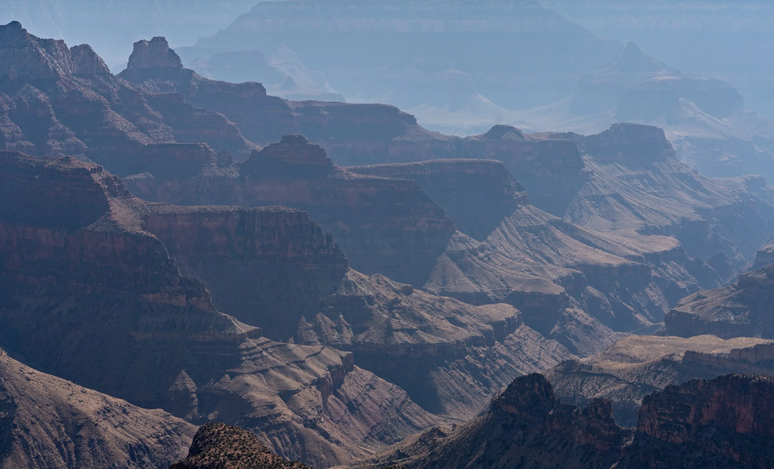Painted Plateaus
Another perspective of the Grand Canyon, focusing on the dramatic plateaus that jut out into the canyon floor. The light rakes across the top of the mesas, emphasizing the immense flat-topped structures that have survived millions of
