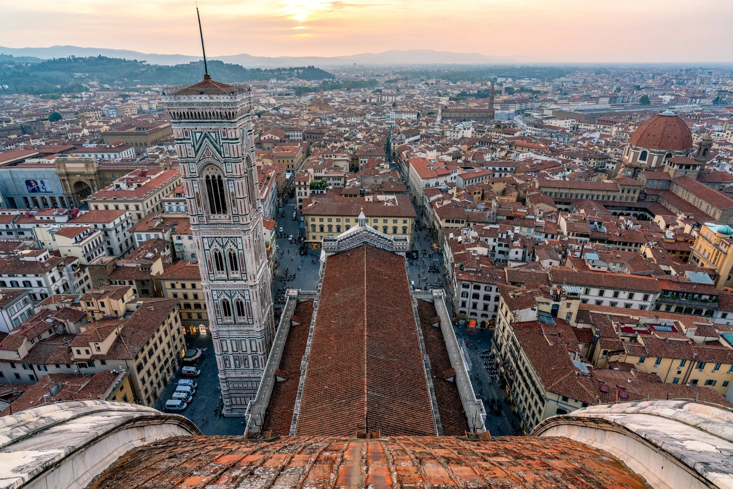 Looking Down from the Duomo
A bird's-eye view looking straight down from the top of Brunelleschi's Dome. This perspective captures the intricate geometric patterns of the cathedral’s roof and the neighboring Giotto's Bell Tower. The shot emphasizes t