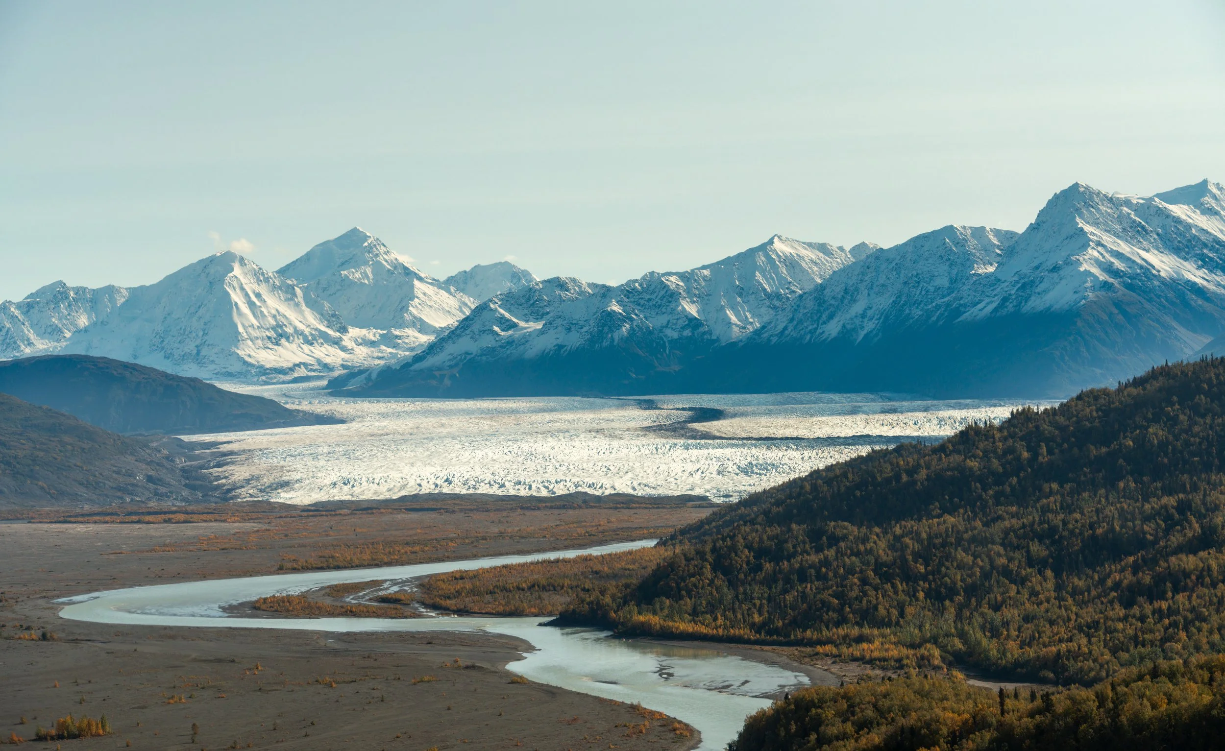 The Glacial River
Moving back to the Alaskan wilderness, this shot captures a massive glacier as it flows toward the sea. The intricate patterns of crevasses and moraines look like natural brushstrokes from this altitude, illustrating the slow but re