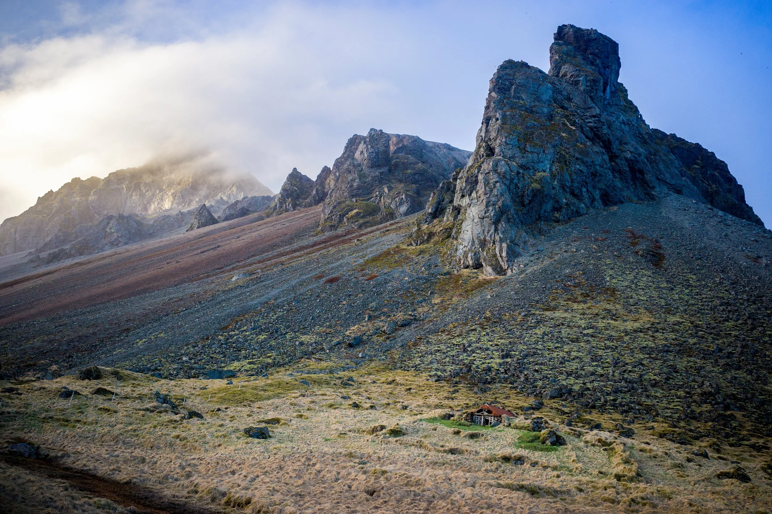 Highland Mist
Moody morning light settles over the jagged ridges of the Icelandic Highlands. The clouds cling to the steep, weathered slopes of the rhyolite mountains, a hallmark of Iceland’s geothermal heart. The presence of a traditional mountain s