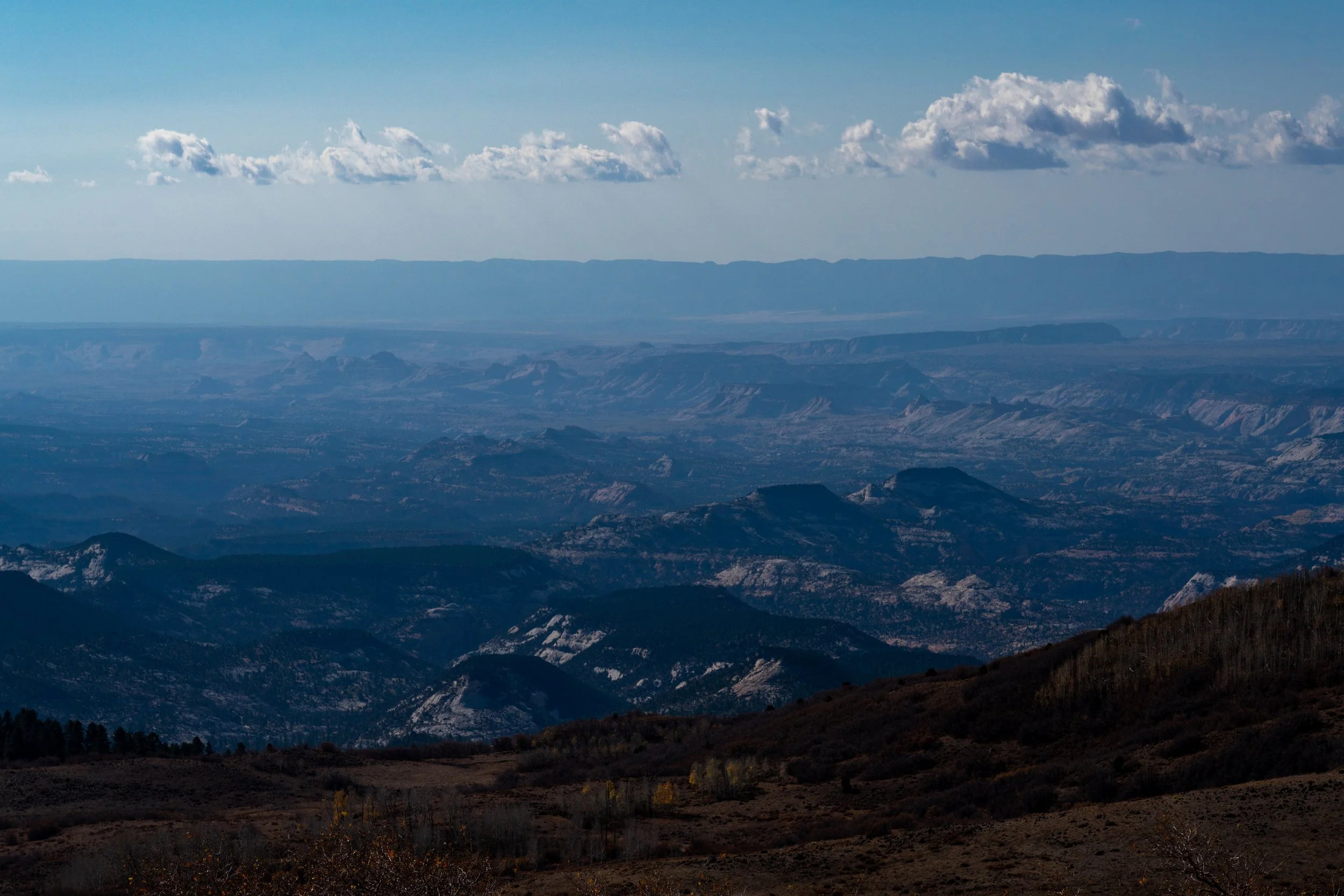 Shadows of the Great Basin
A wide-angle landscape looking across the vast, undulating hills of the high desert. The soft, midday light reveals the subtle textures of the sagebrush and the distant, rugged mountain ranges that define the desolate beaut