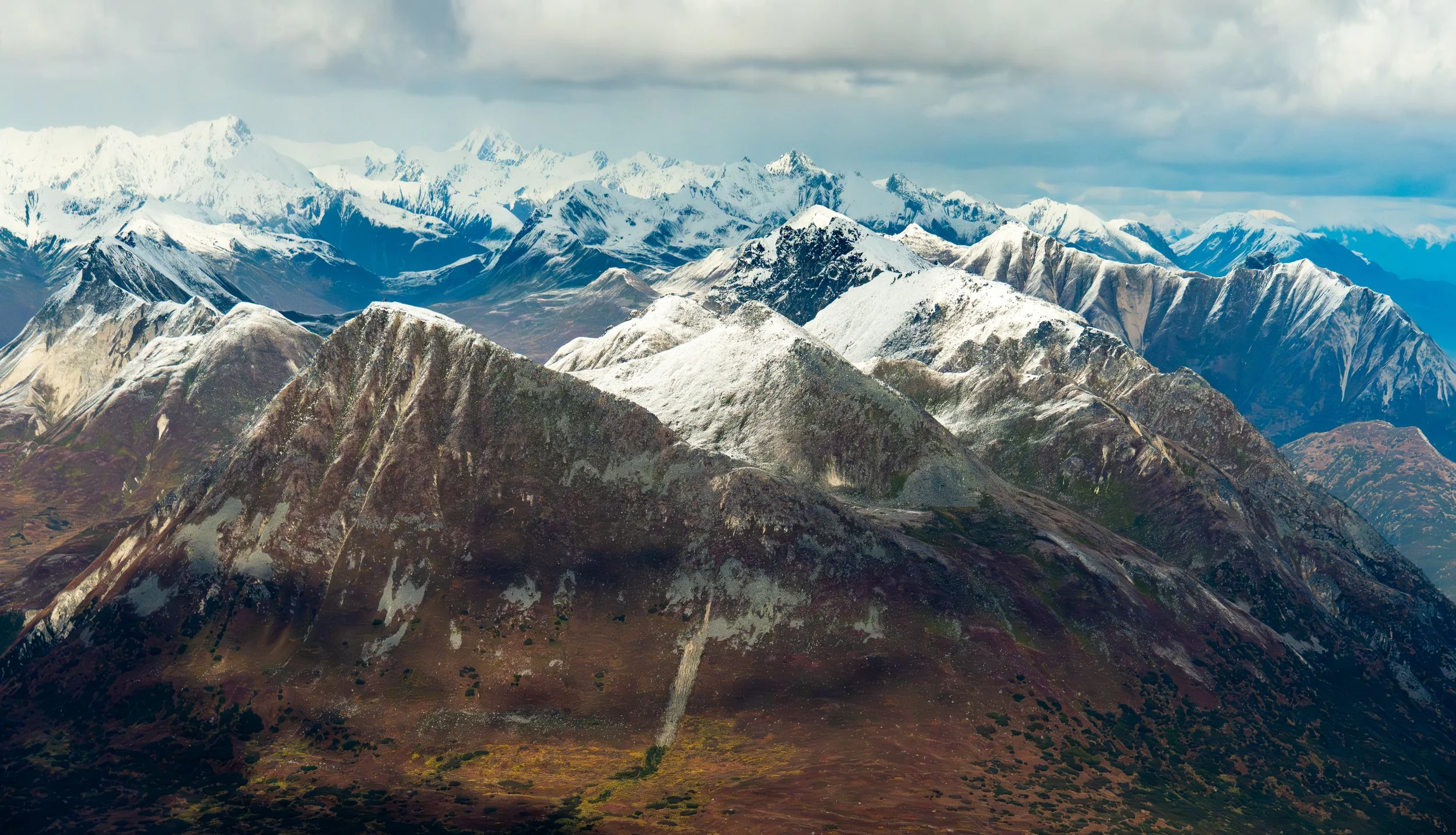 The Heart of Denali
Looking across the vast, tundra-covered valleys and jagged ridges of the Alaska Range within Denali National Park.