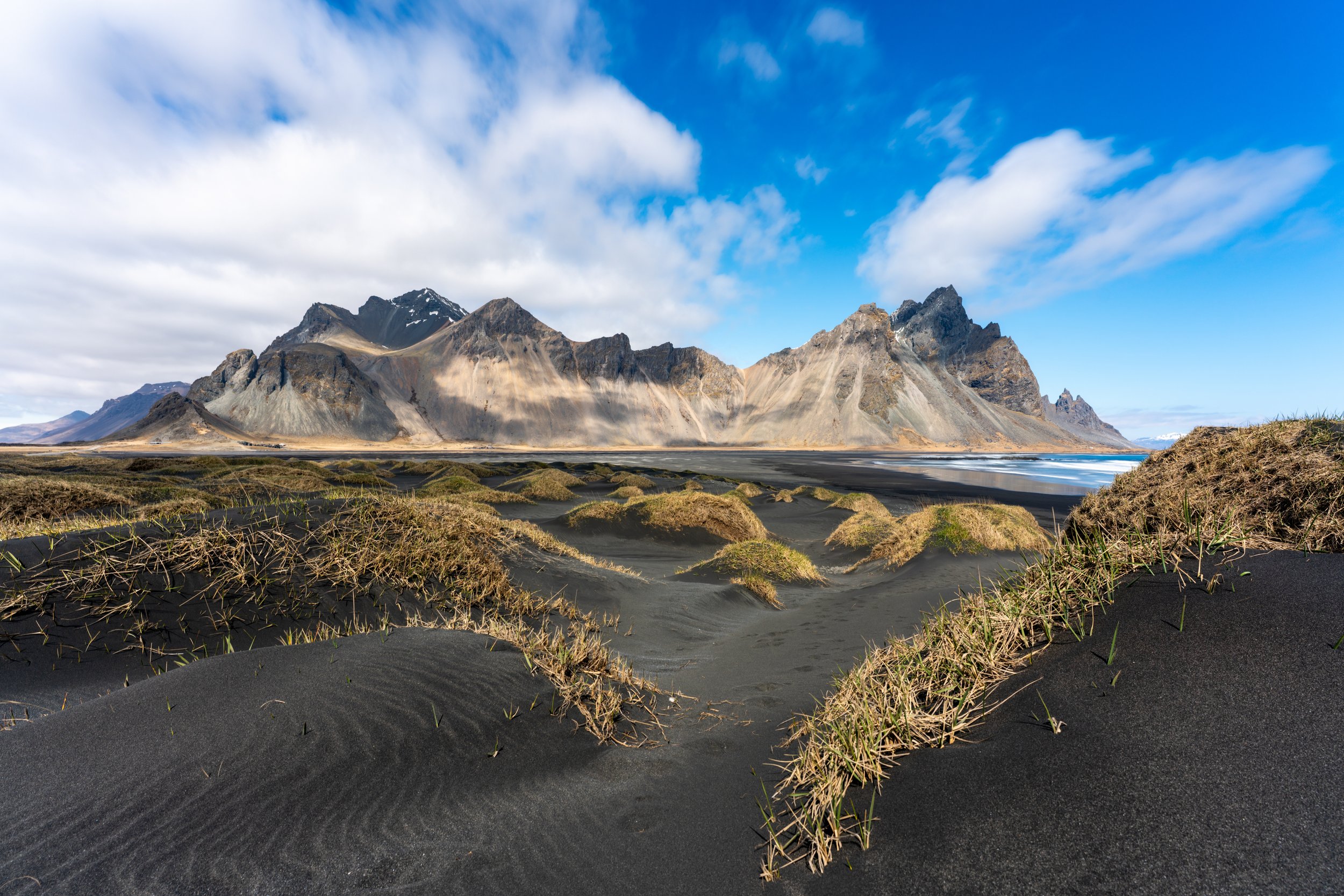 Stokksnes Sands
The dark, wind-sculpted dunes of a black sand beach at the foot of the Vestrahorn's jagged ridges.