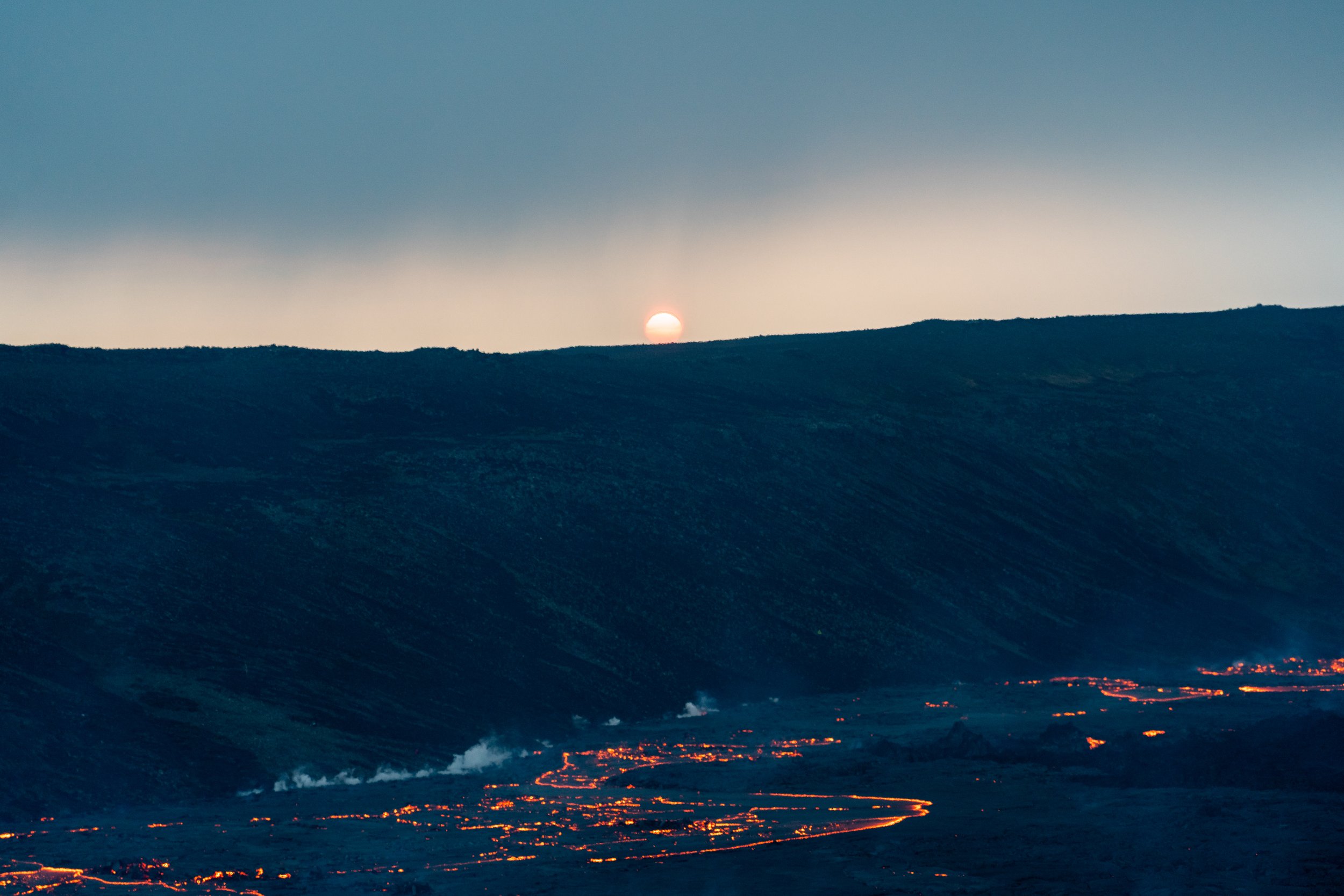 Moonlit Eruption
As night falls over the Reykjanes Peninsula, the moon hangs peacefully above the violent glow of the Fagradalsfjall crater. This long-exposure shot captures the duality of the scene: the cold, silent light of the moon juxtaposed with