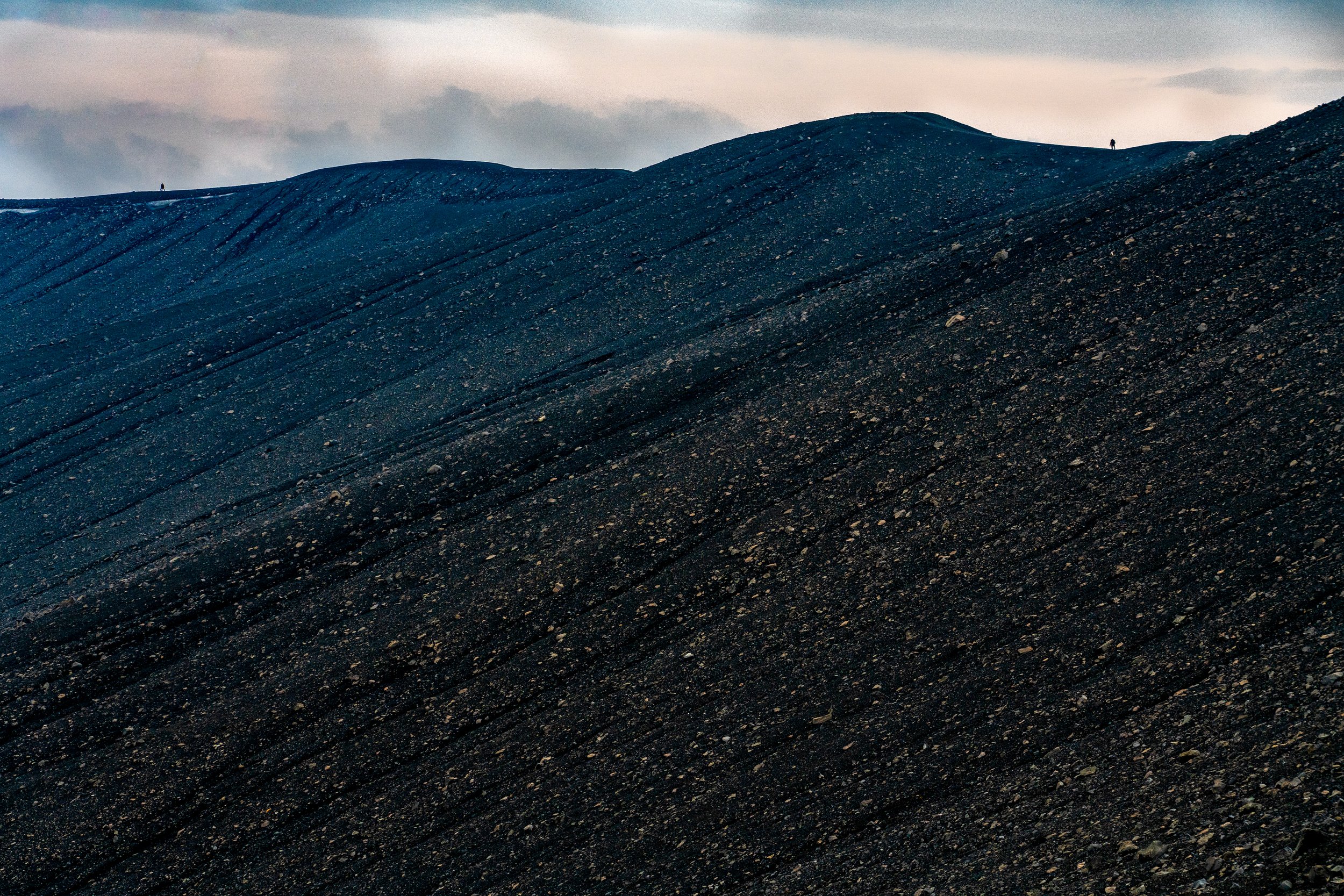 he Scorched Highland

Description: A wide-angle view of the rugged ridges surrounding the eruption site. Years of volcanic history are written into these hills, with the newest layers of black ash and stone now settling over the ancient landscape. Th