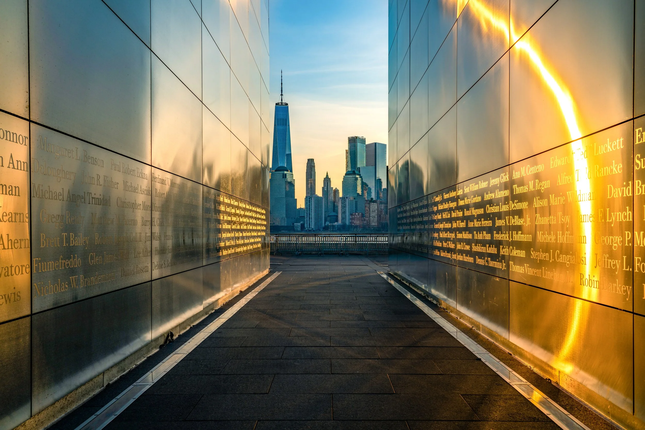 Reflecting on the Skyline
A powerful perspective from within the Empty Sky Memorial in Liberty State Park. The twin stainless steel walls reflect the golden sunset and the One World Trade Center across the Hudson River. This shot captures the memoria
