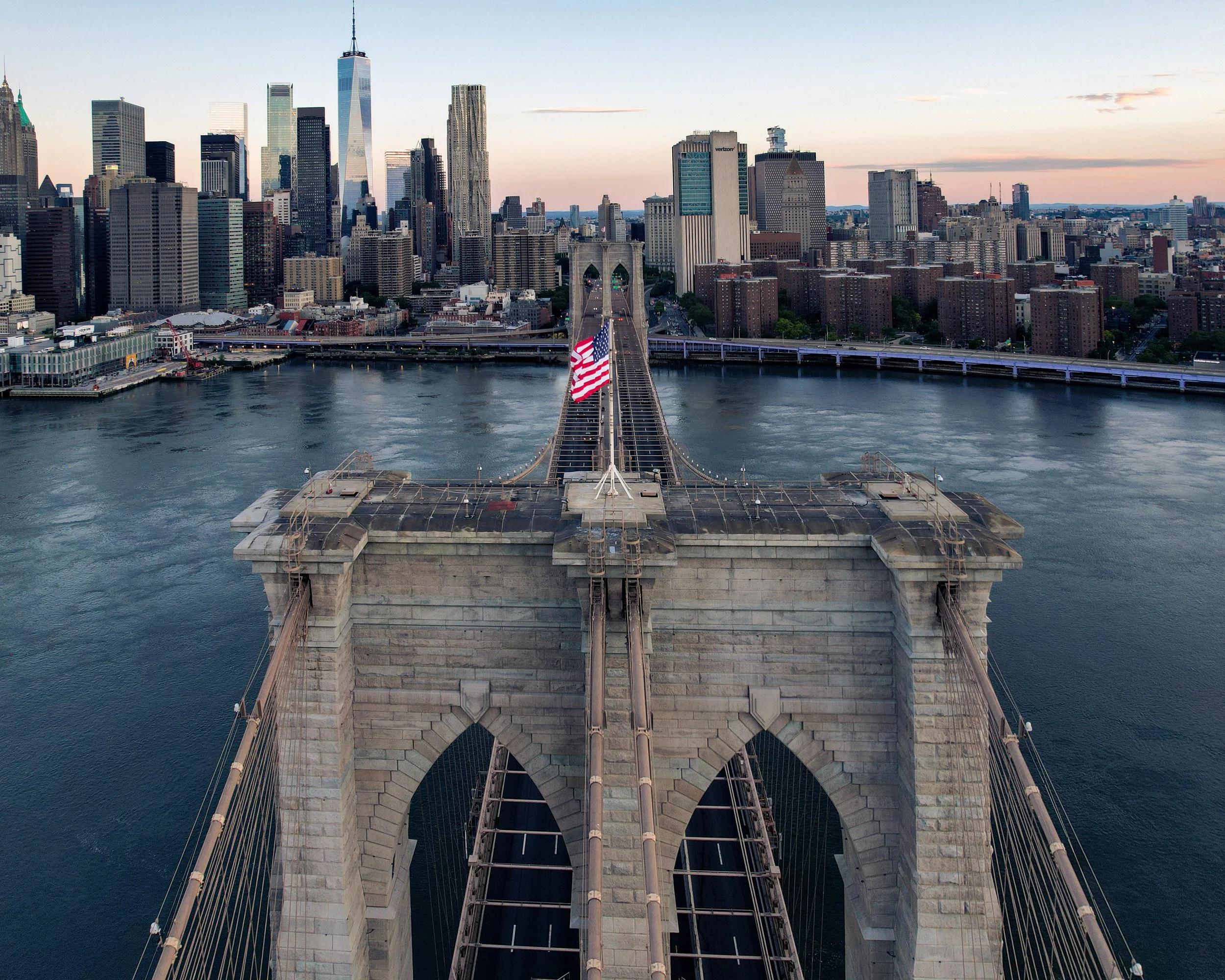 The Granite Gateway
A symmetric, low-altitude perspective of the Brooklyn Bridge towers. This shot emphasizes the neo-Gothic arches and the intricate web of suspension cables that have defined the East River skyline since 1883. Looking toward Manhatt