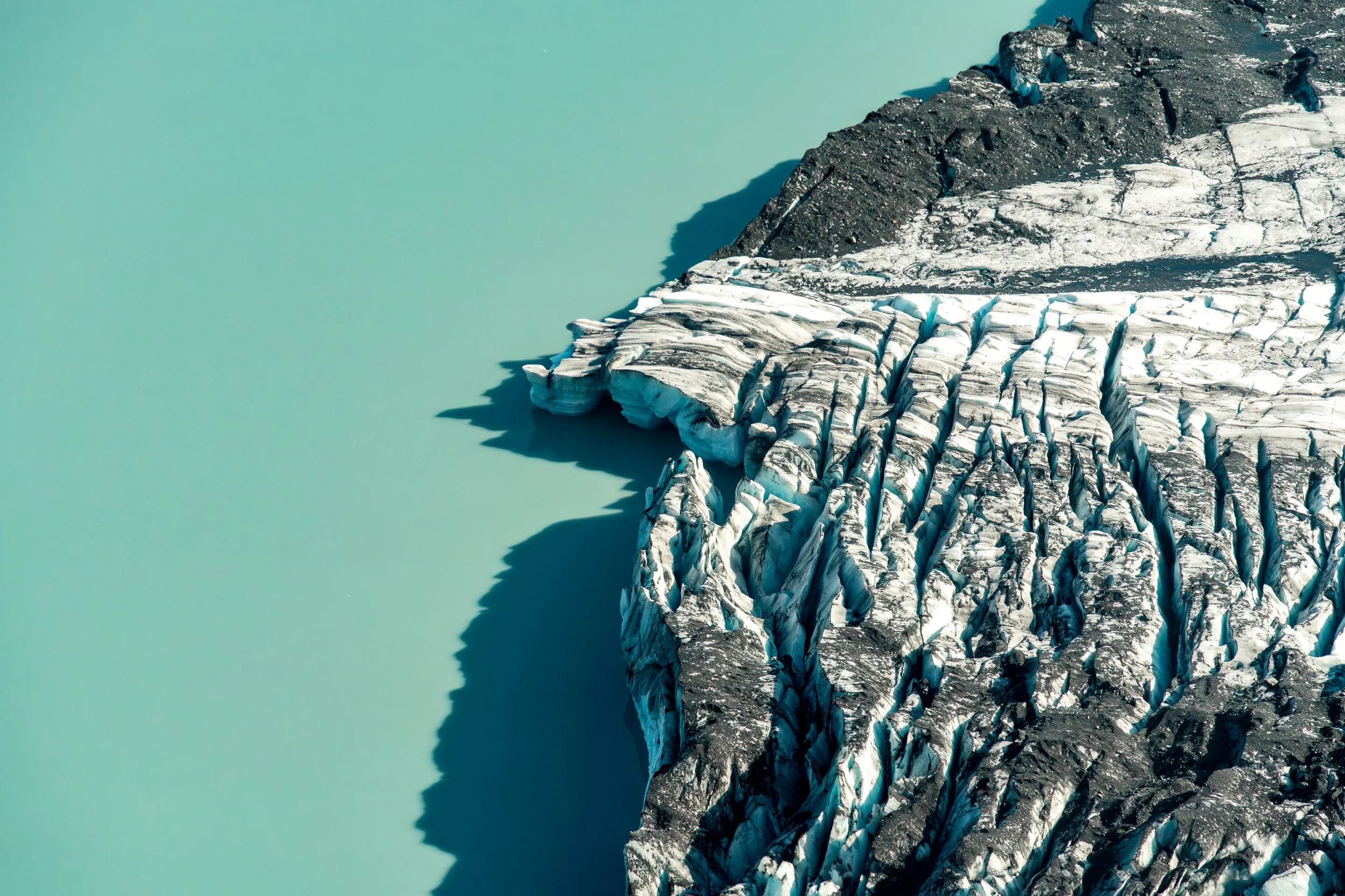Glacial Detail
A high-contrast, top-down study of glacial ice. This image captures the raw texture of the "river of ice," where pressure and movement create deep fractures and shimmering teal highlights. It’s an abstract look at the powerful geologic