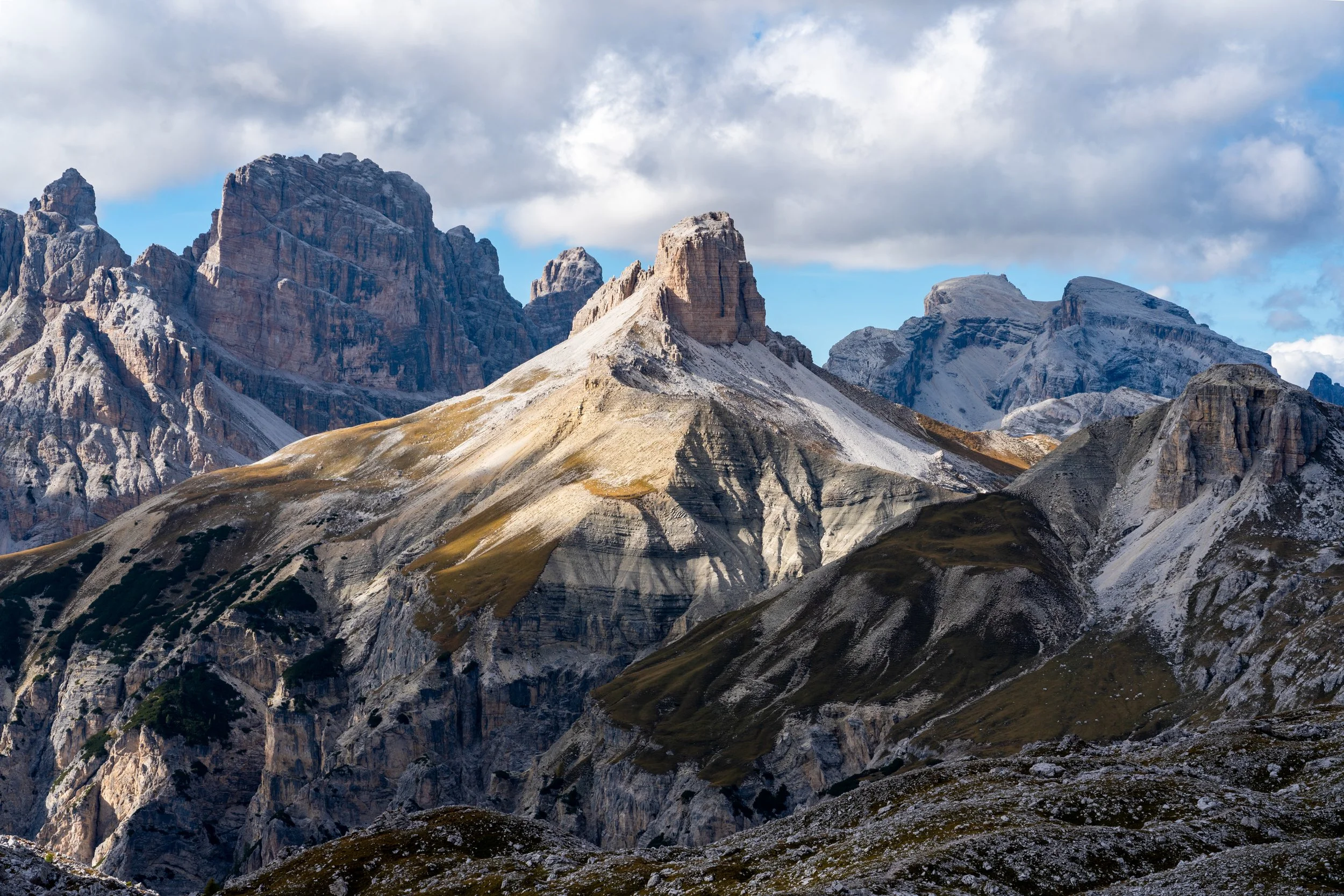 The Jagged Monoliths
Looking up at the massive, vertical limestone pillars of the Cinque Torri rock formation. This low-angle shot emphasizes the sheer scale of the rock towers against a crisp Alpine sky, highlighting the intricate textures and fissu