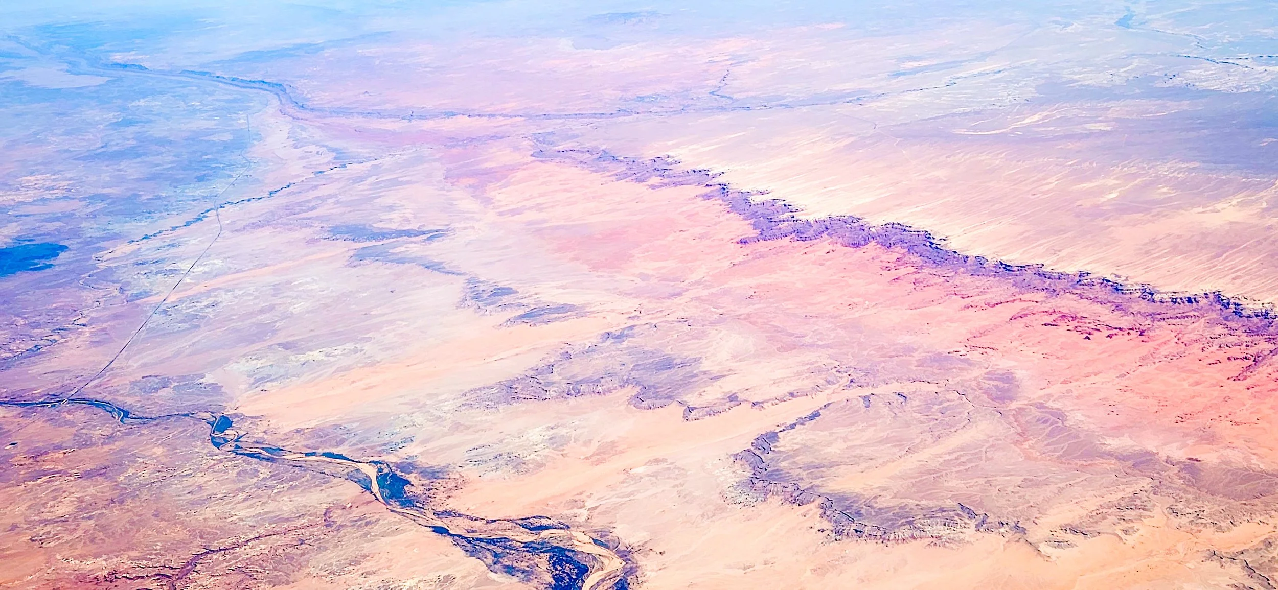 Painted Arteries
An expansive aerial view over the Arizona desert, where ancient riverbeds and geological erosion create a delicate, vein-like network across the landscape. The soft pastel hues of the sediment contrast with the rugged terrain, illust