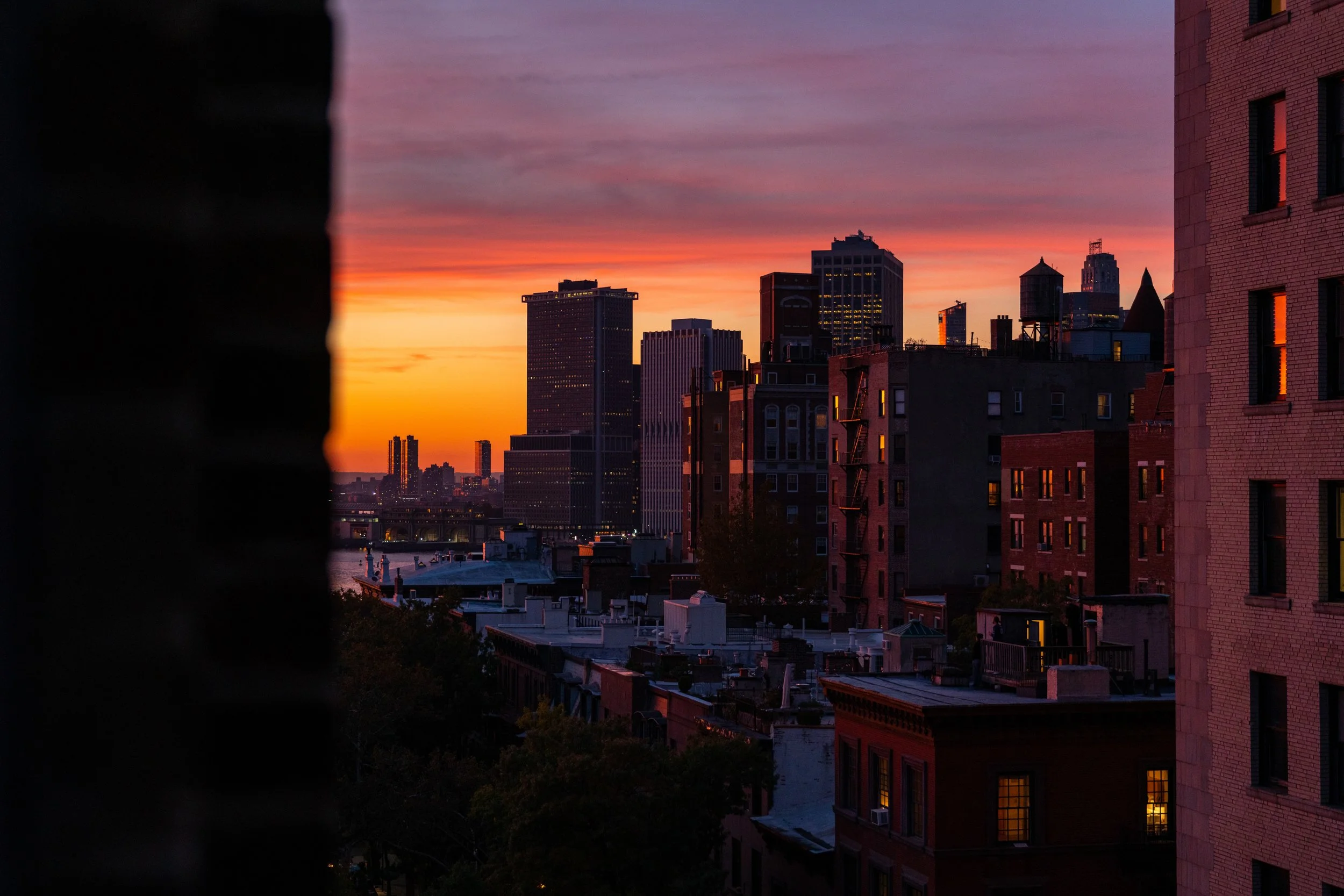 Golden Hour in the Heights
A warm, cinematic view of the Brooklyn Heights skyline captured through my window at sunset. The frame tries to balancs the dark interior silhouettes with the vibrant oranges and purples of the sky. This shot offers an inti