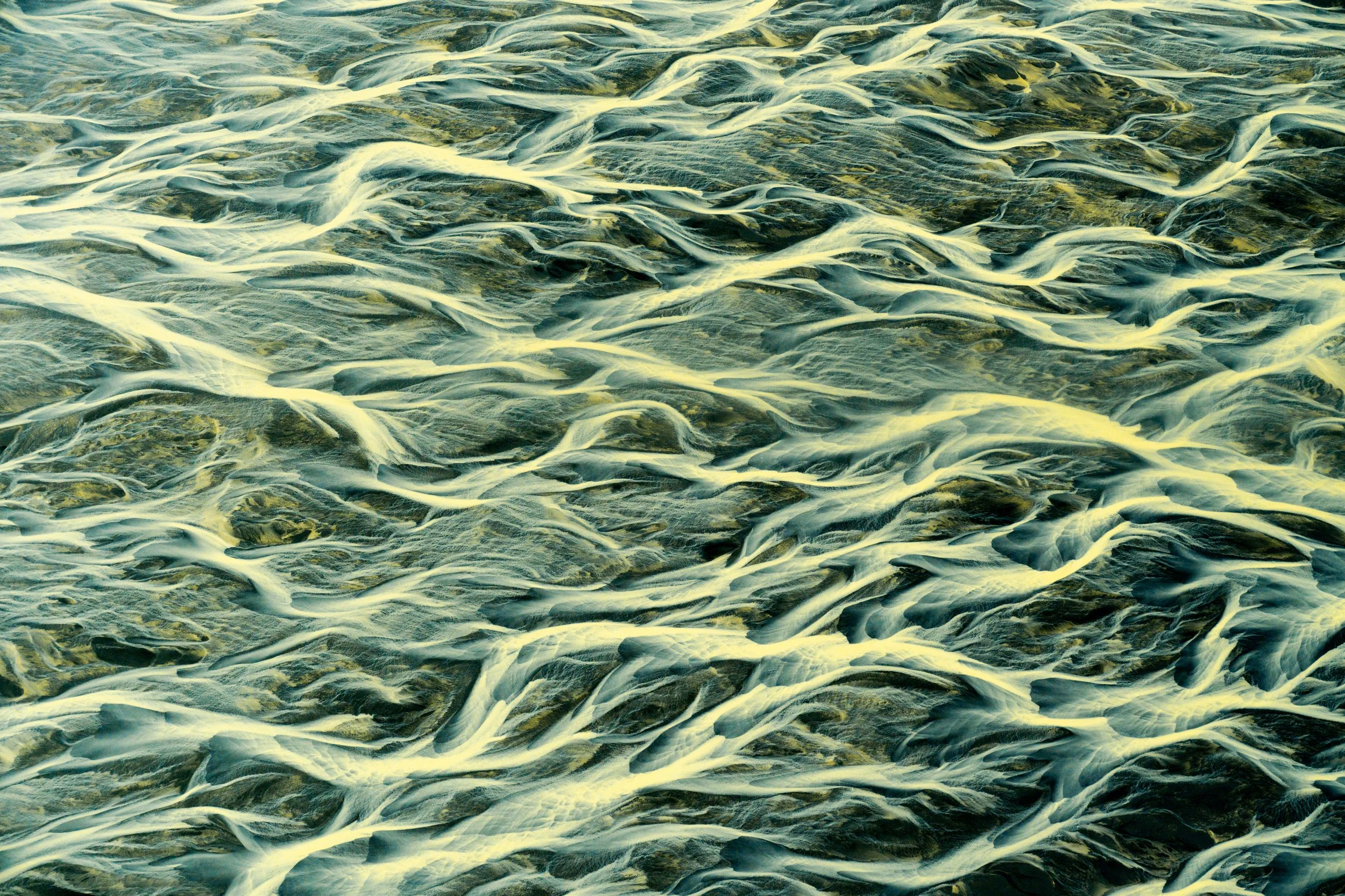 Elemental Convergence
The final abstract in the series, this shot captures the overlapping textures of water, silt, and sand. It serves as a testament to the four elements of Iceland: ice, fire (the volcanic sand), air (the perspective), and water, a