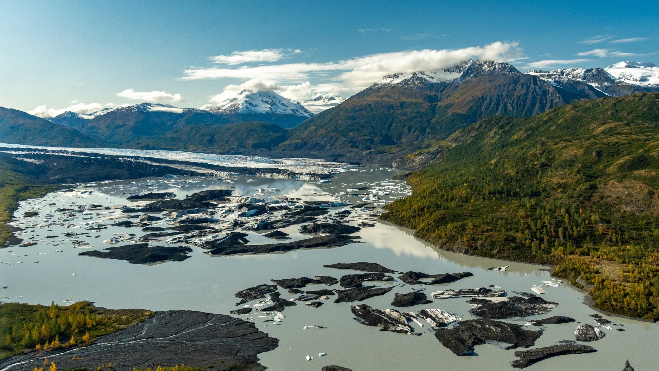 Prince William Sound
A wide-angle landscape where the mountains meet the sea. This shot captures the calm, reflective waters of a glacial fjord, dotted with small icebergs that have calved from the nearby tidewater glaciers. The composition emphasize