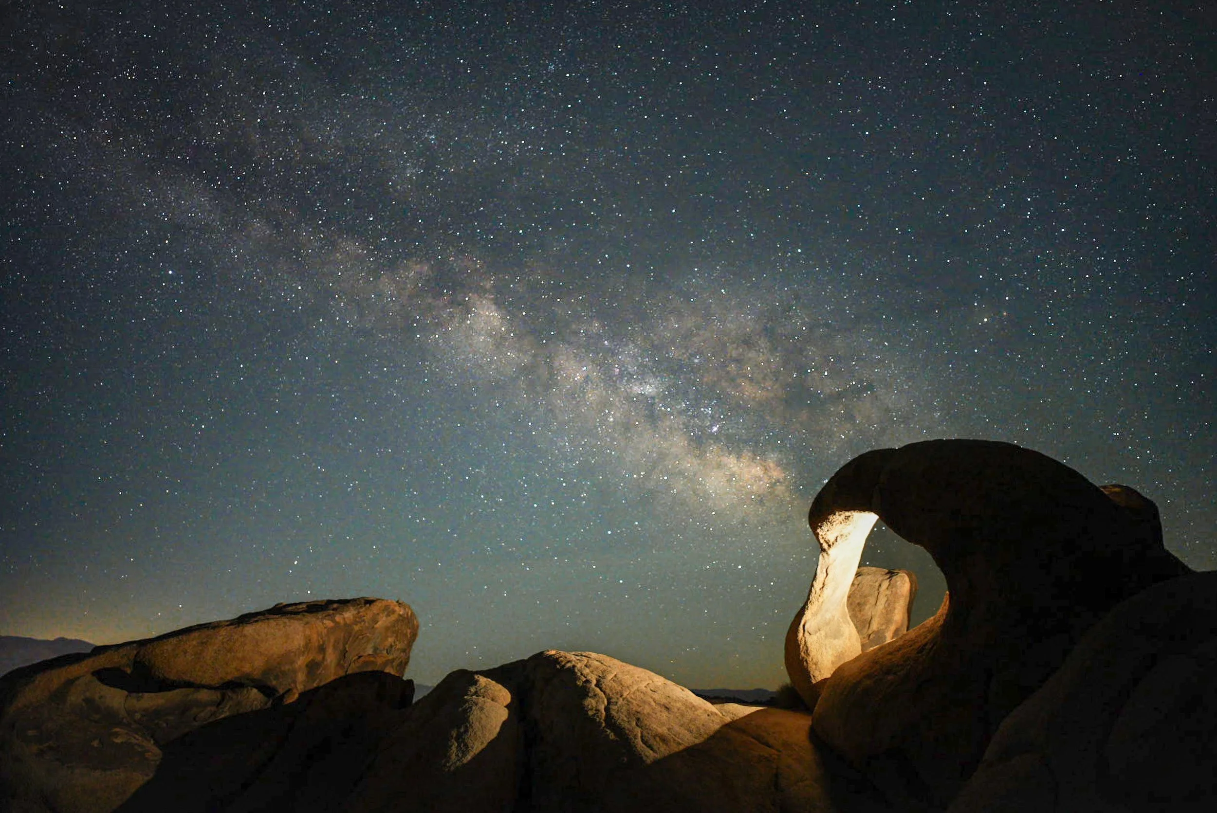 Alabama Hills
Captured in the Alabama Hills of California, this night shot features the jagged granite peaks of the Sierra Nevada mountains framed by the rounded, orange boulders of the foreground. The Milky Way stretches subtly across the dark sky a