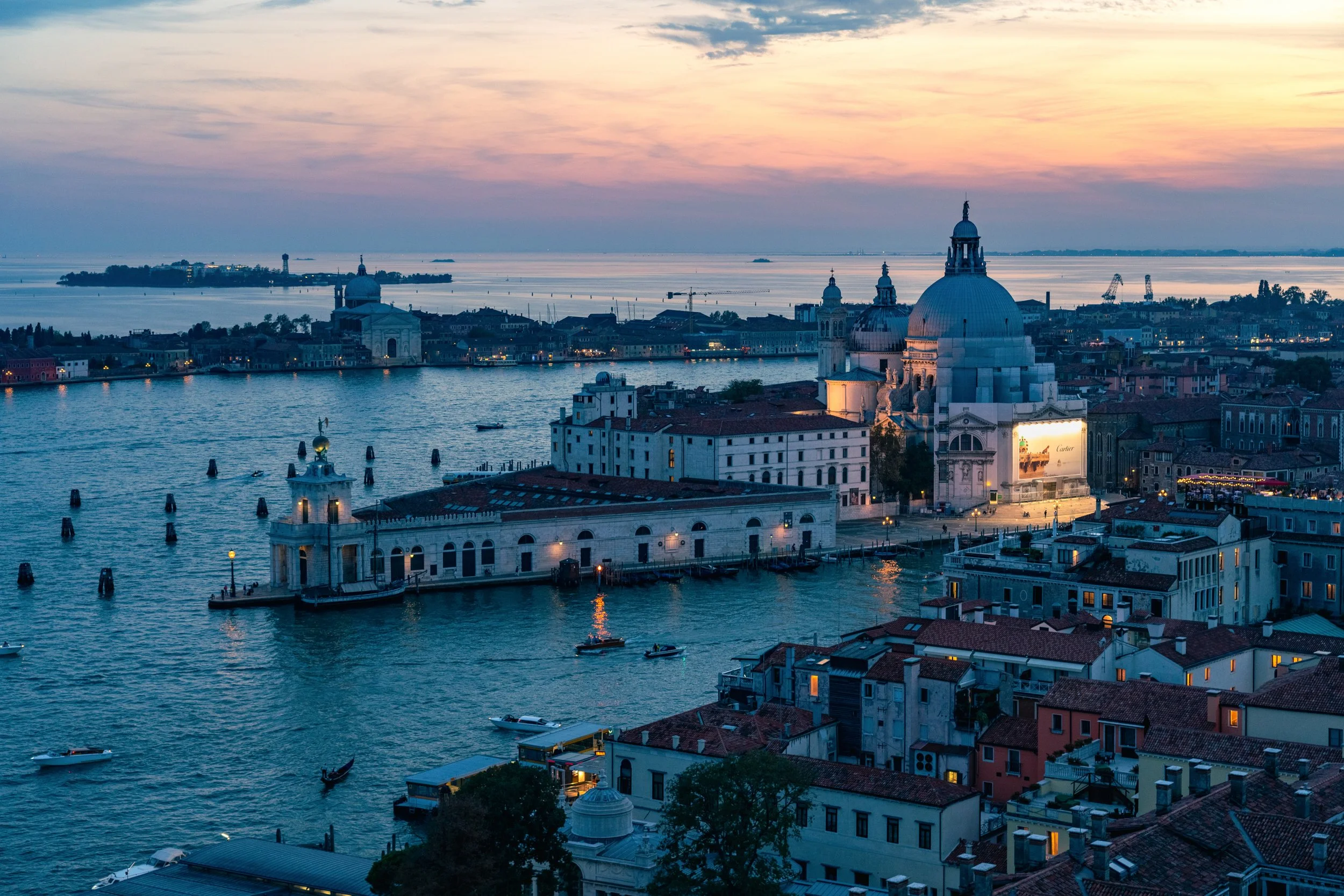 The Venice Glow
A sweeping evening view across the Venetian Lagoon toward the iconic domes of Santa Maria della Salute. This shot captures the city of Venice as the twilight turns the water a deep blue and the distant streetlights begin to flicker on