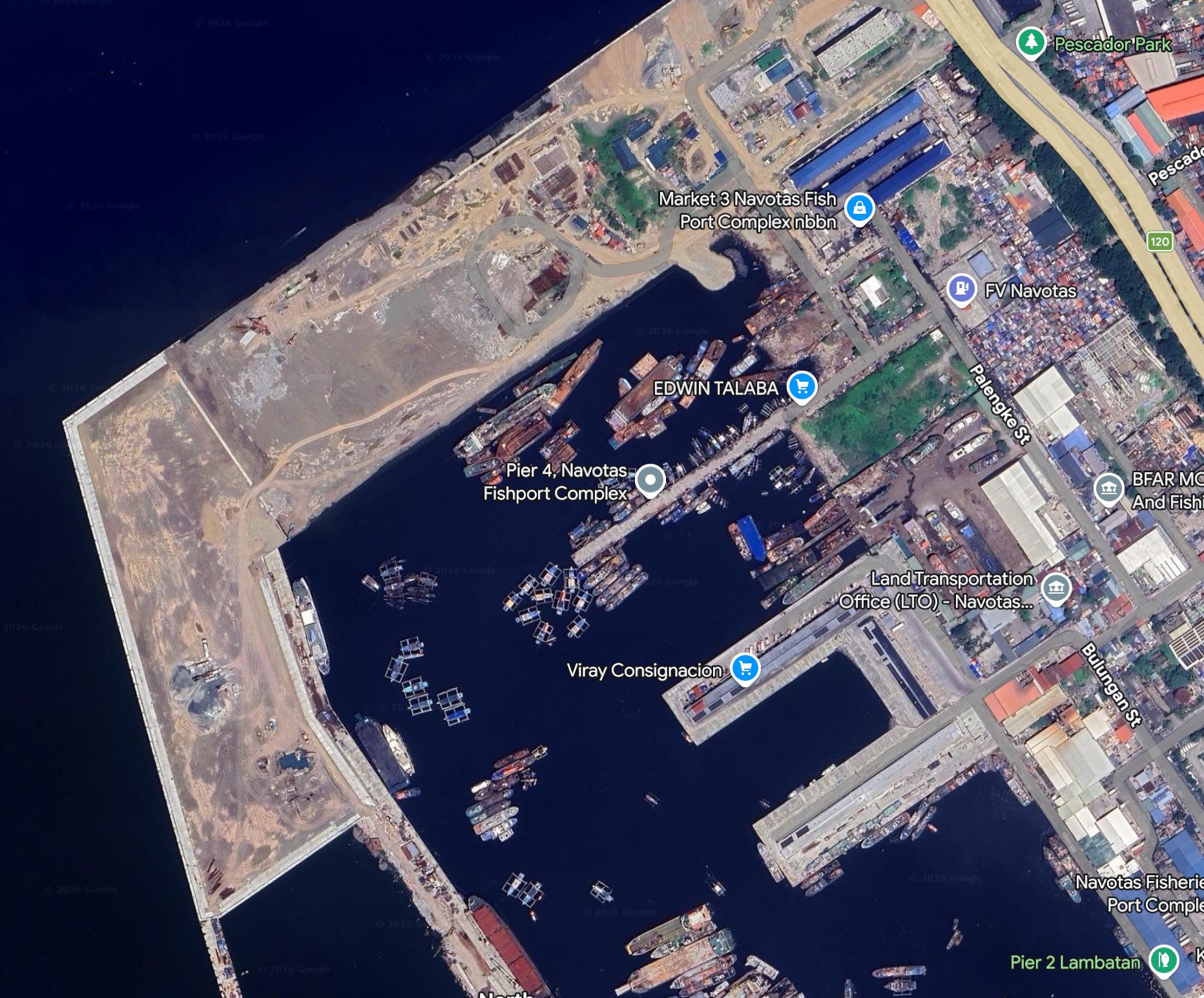 Aerial view of Navotas Fishport in the Philippines showing docks, boats, and surrounding buildings along the water.