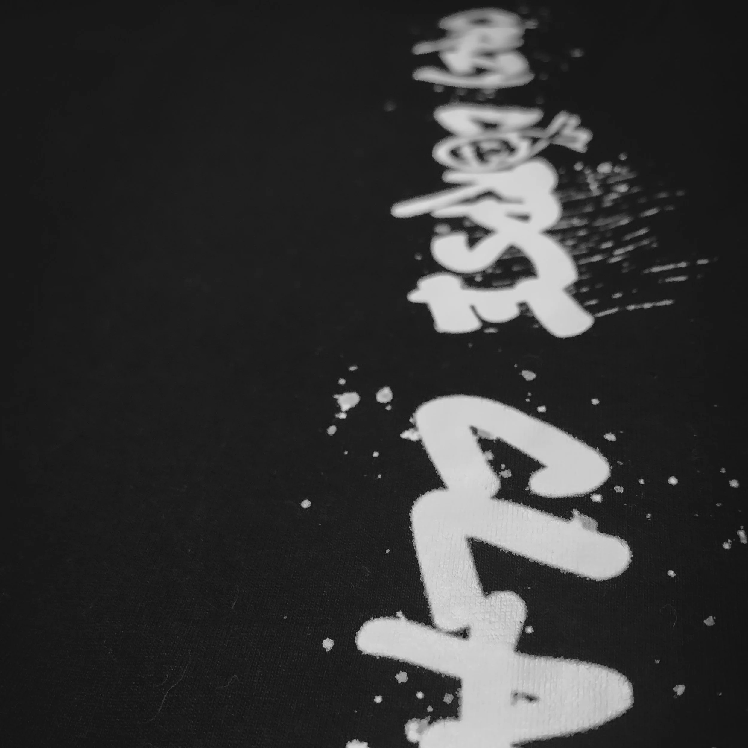 Close-up of white text on black background with splatter effects.