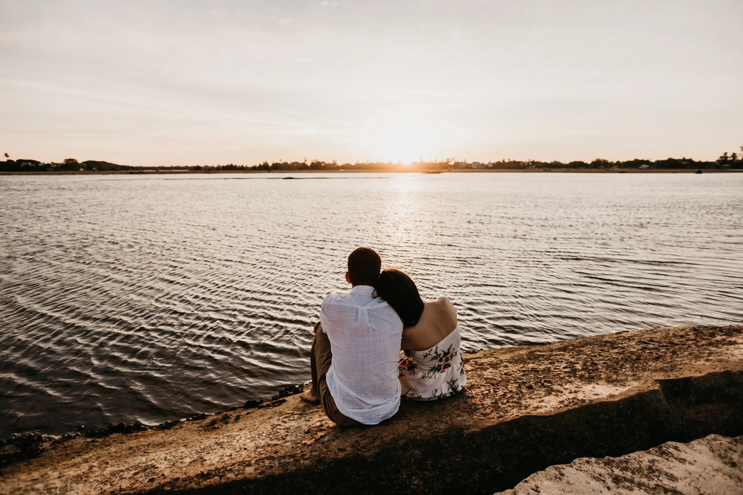 Couple sitting together beside the water