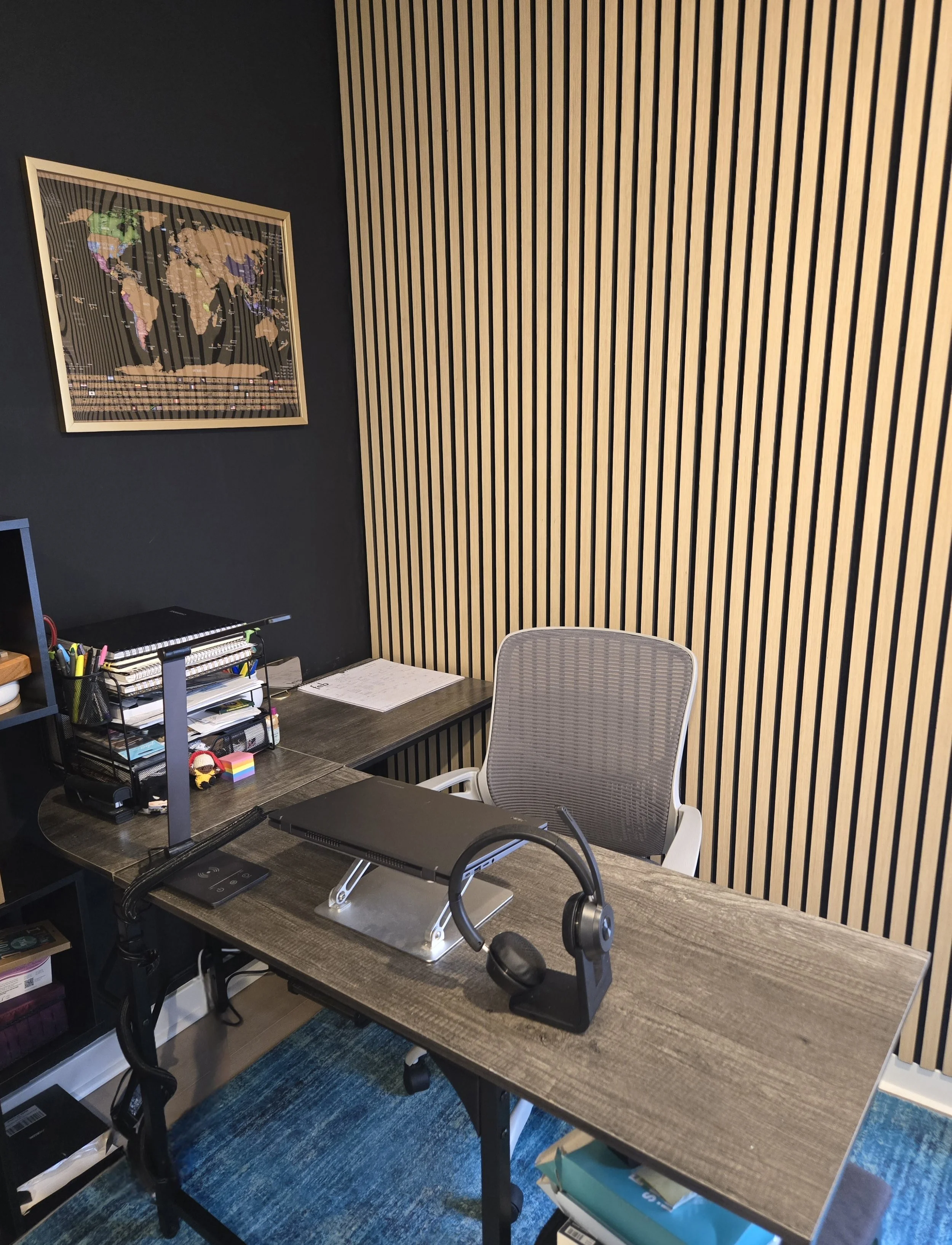 picture of a home office with a desk and travel map in background
