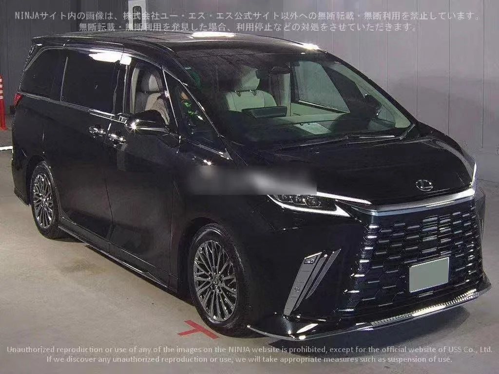 Black minivan parked indoors with a large front grille and sleek headlights.