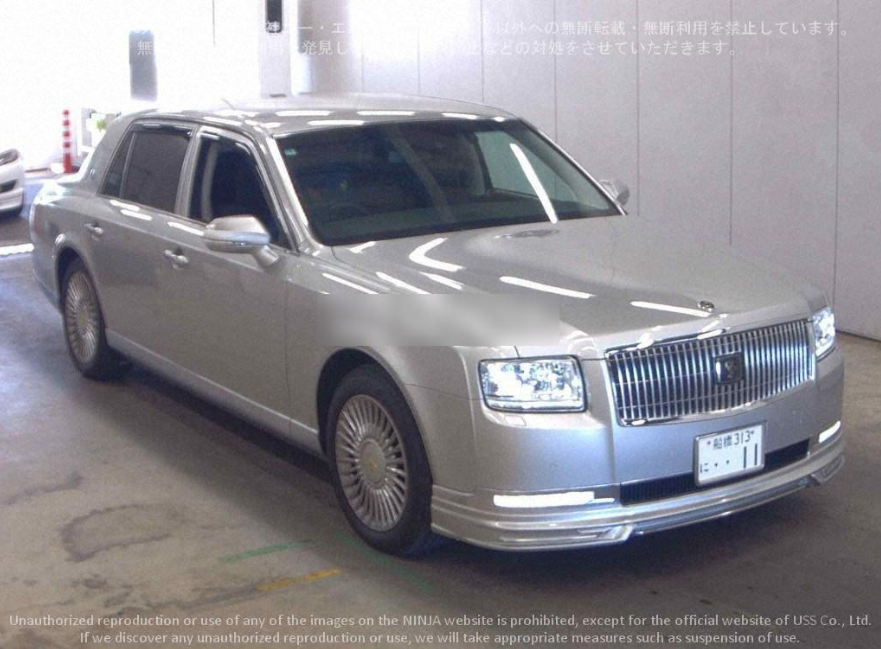 Silver luxury sedan parked indoors in a well-lit space.