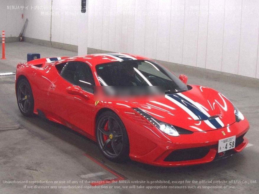 Red Ferrari sports car with racing stripes inside a garage.