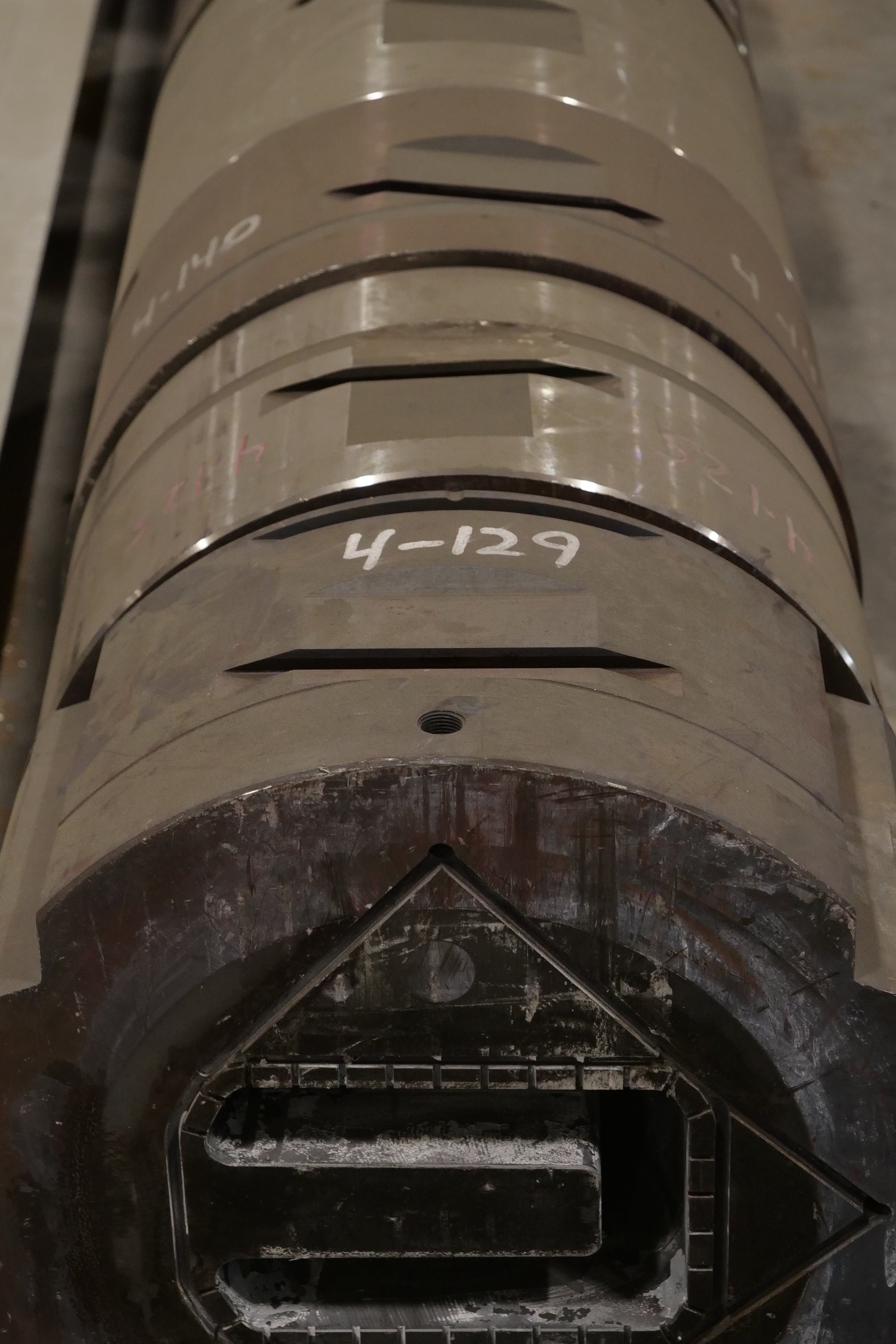 Close-up of an industrial mold or casing with labeled sections, including '4-129', showing an interior cavity with a black residue at the bottom.