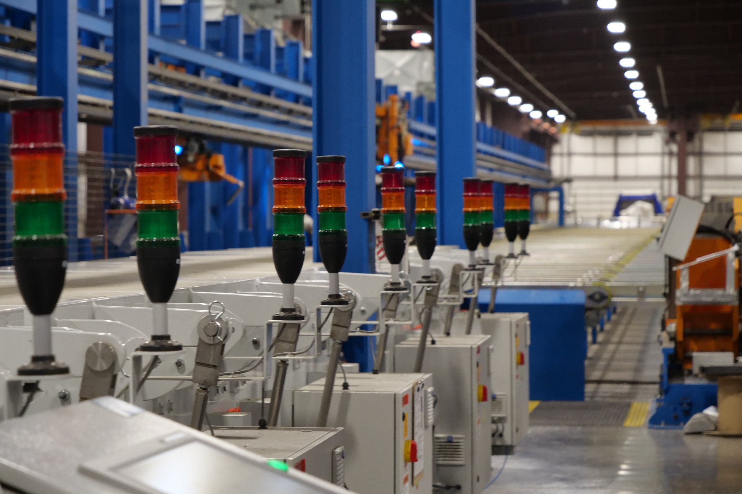 Industrial facility with electronic control panels and machinery in a warehouse.