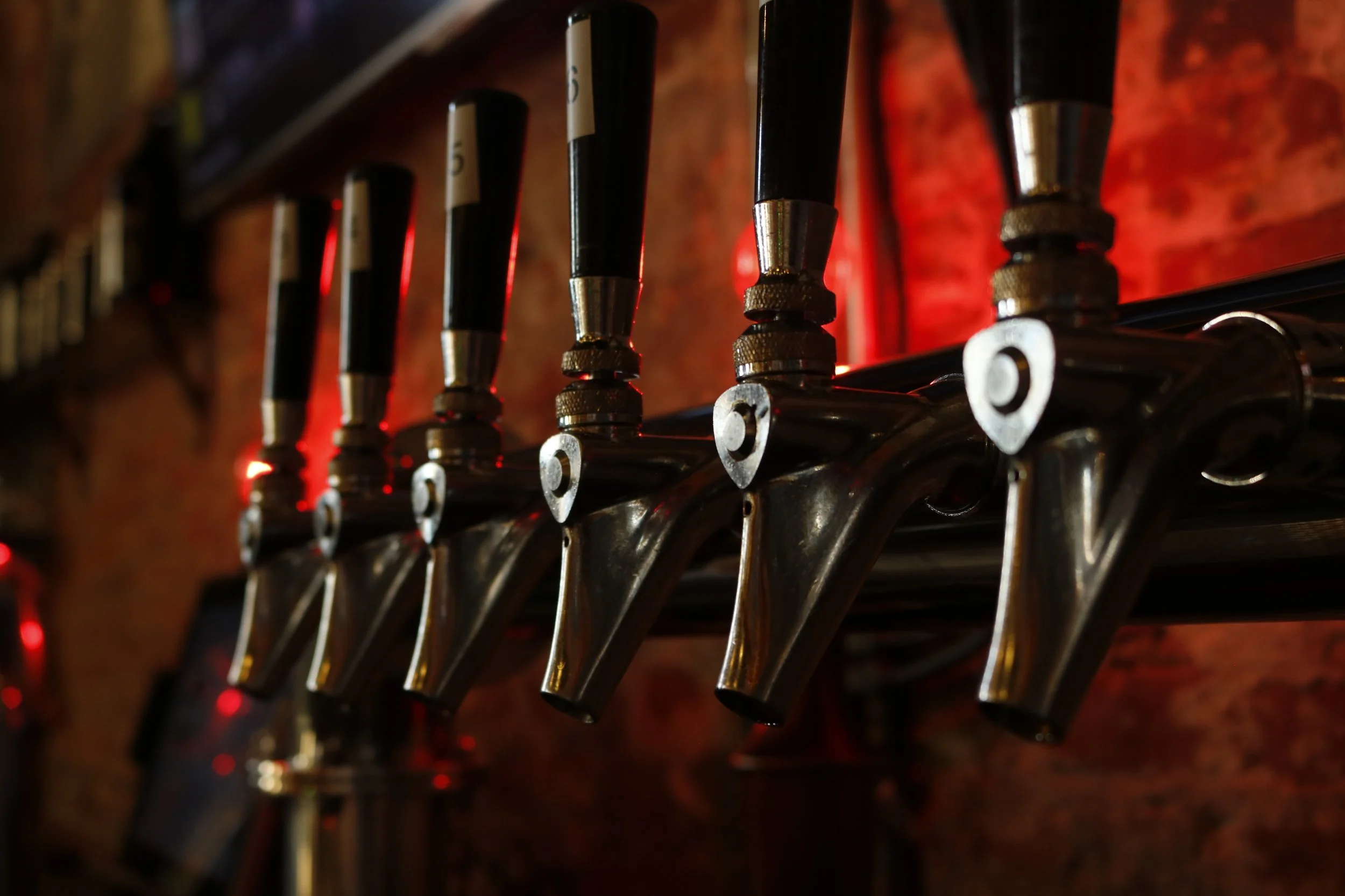 Close-up of metallic keys on a key rack, with a dark and warm background.