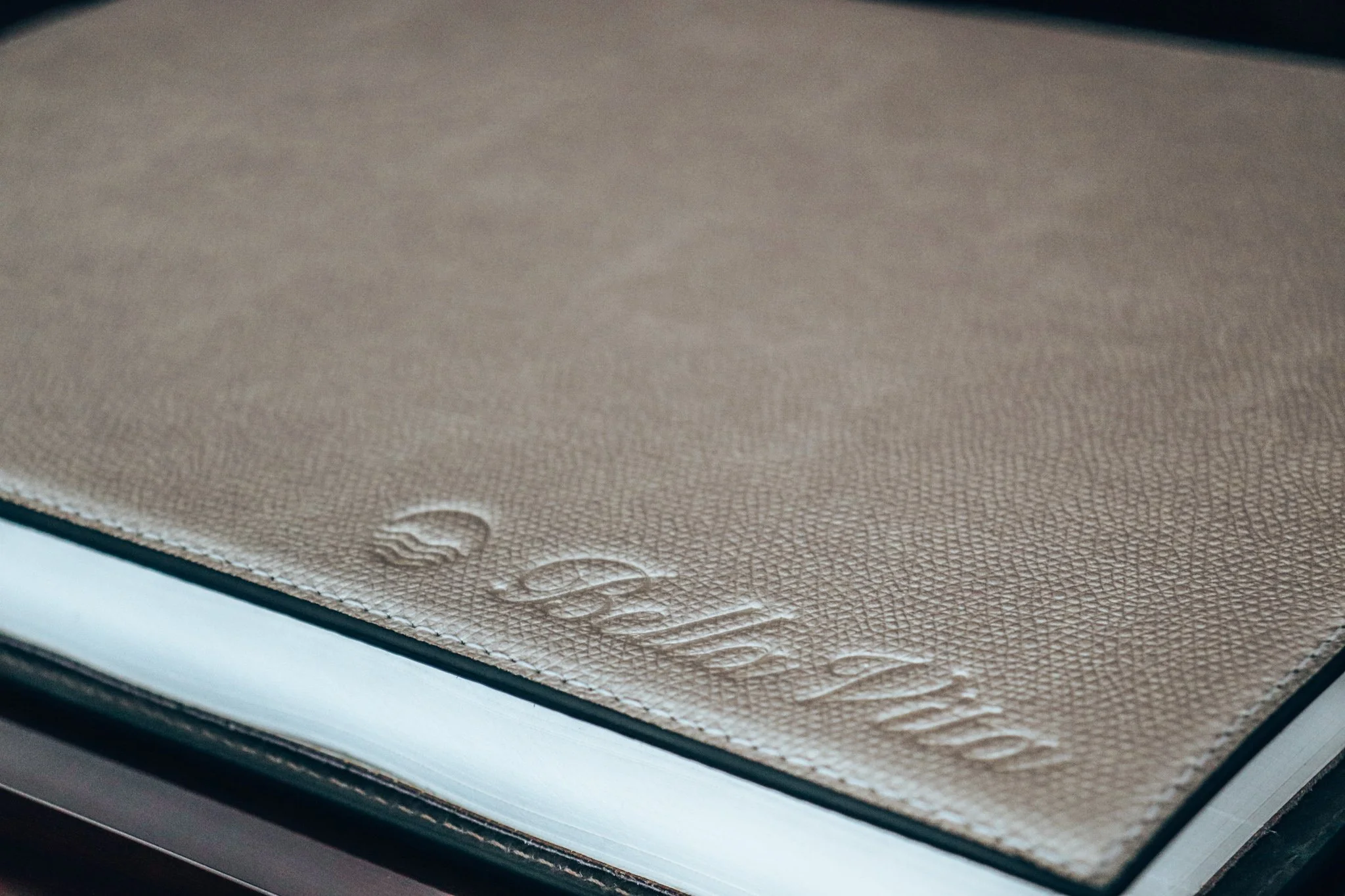 Close-up of a textured leather Giobagnara  Guest book with the words 'Bella Vita' embossed on the cover.