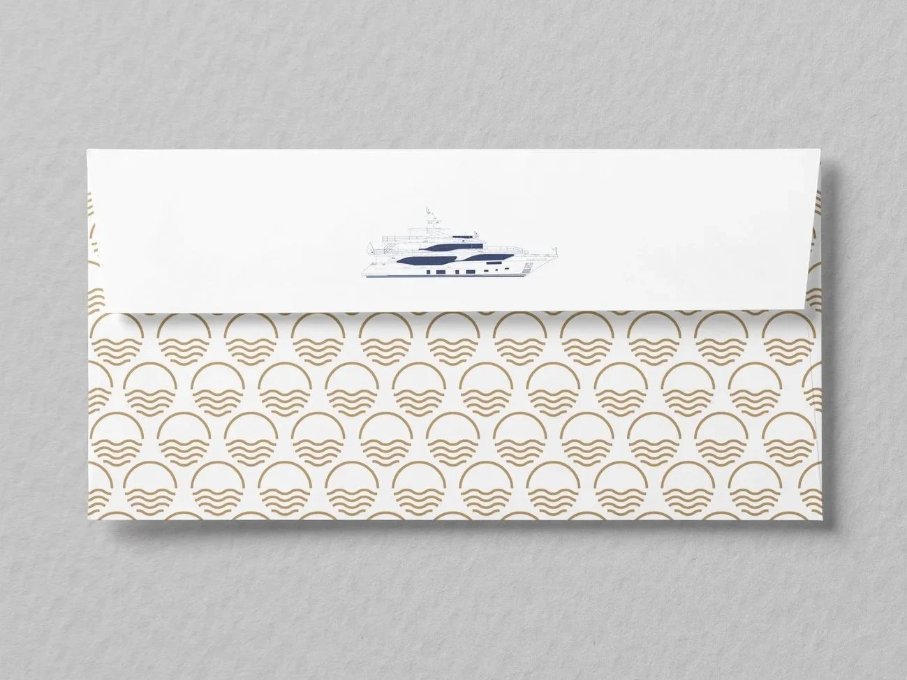 Envelope with gold wave pattern and an illustration of a yacht on the flap