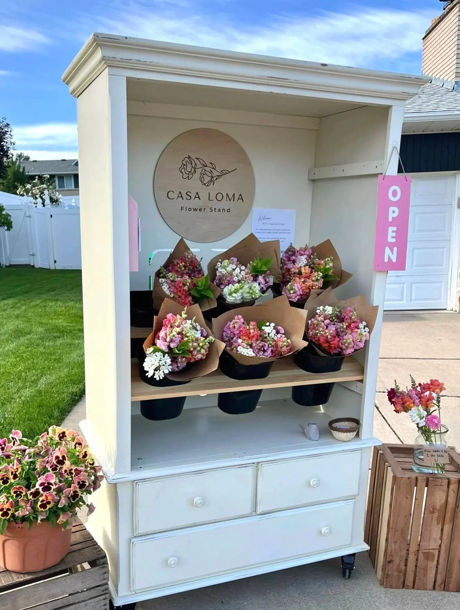Locally grown flower bouquets displayed at a suburban Centerville, Utah flower stand, ready for purchase.