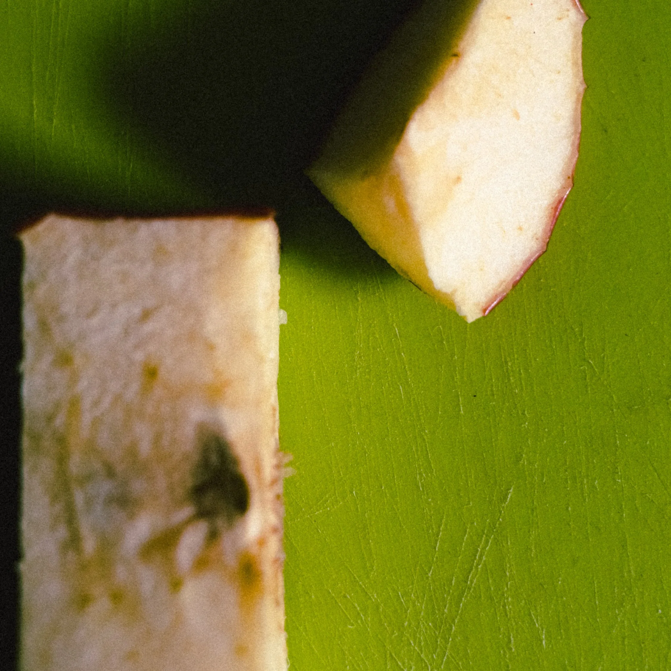 Close-up of apple slices on a green cutting board.