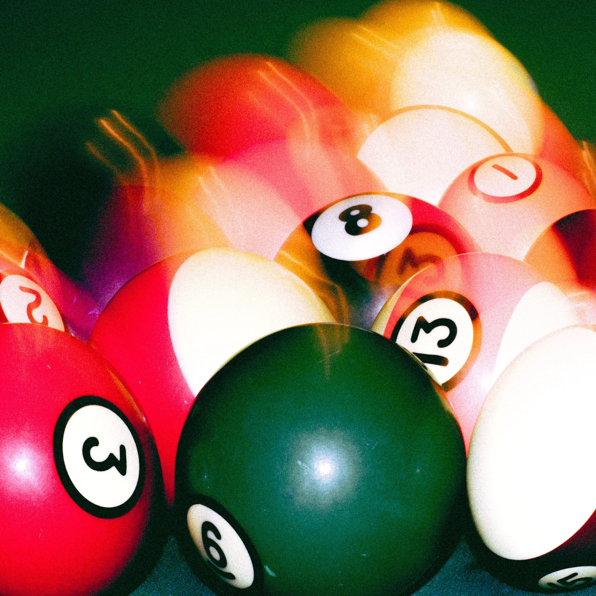 A close-up view of colorful billiard balls, including number 3, 6, 8, 11, 13, and 15, with some blurred motion effects.