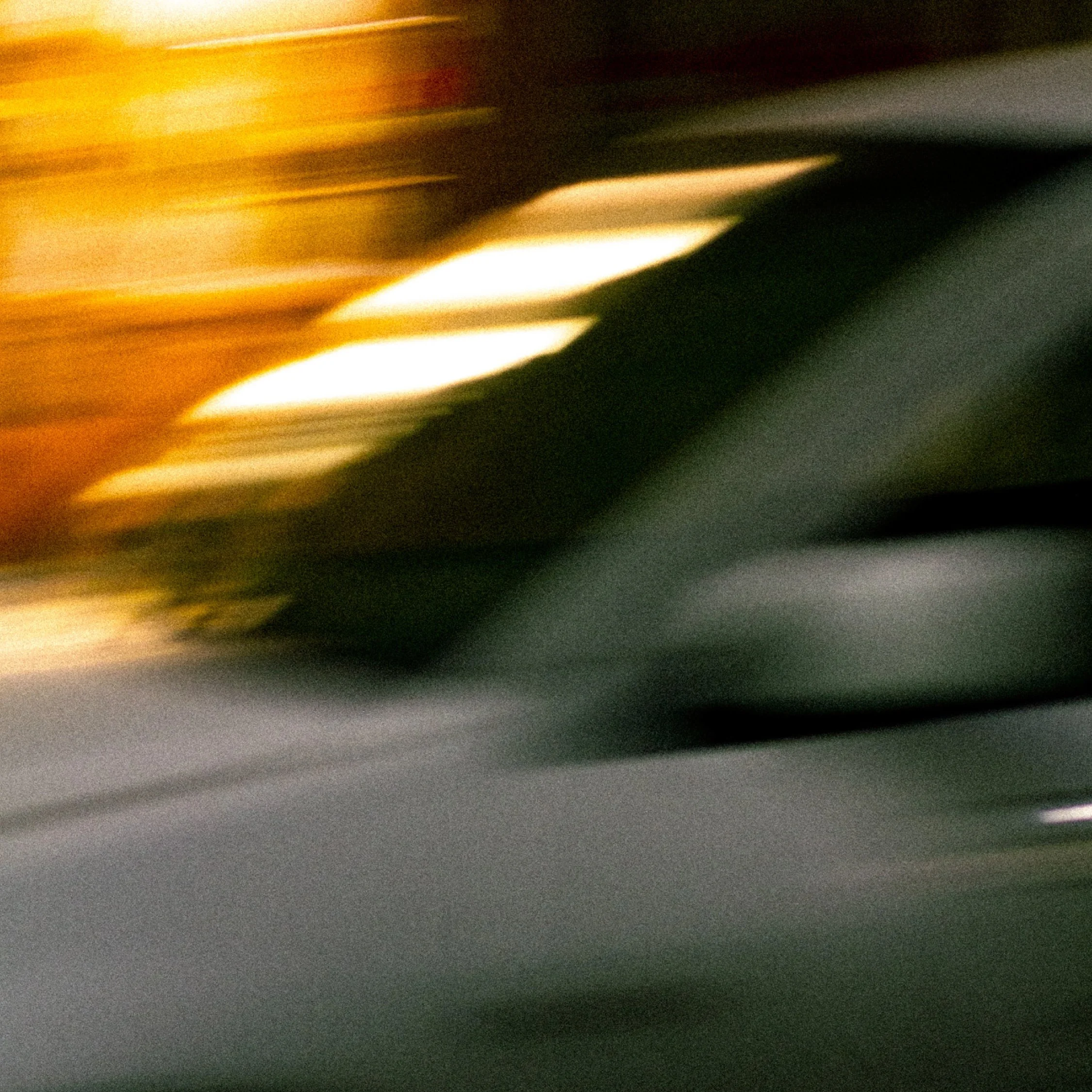 Blurry photo with streaks of yellow, white, black, and gray colors.