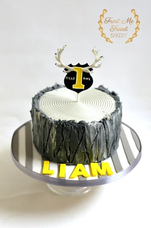 deer+and+tree+trunk+first+birthday+cake+grey+and+yellow.webp