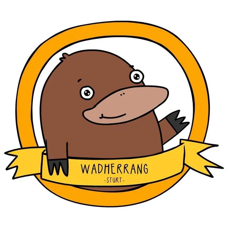 Cartoon illustration of a platypus with a yellow ribbon and border, with the word 'WADHERRANG -STURT-' on the ribbon.