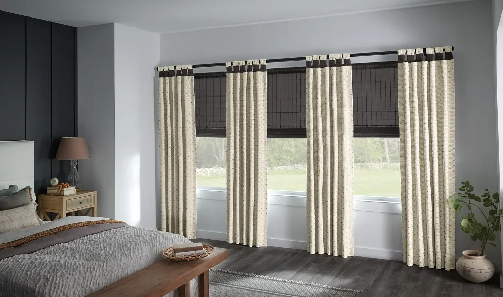 Wrapped tab decorative drapery panels with woven Roman shades