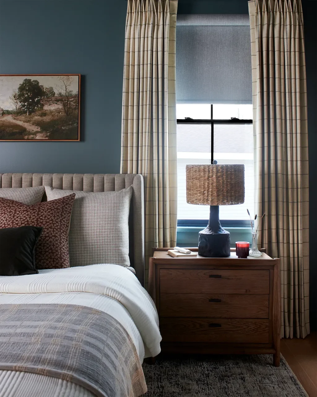 Layered draperies and roller shades in a bedroom