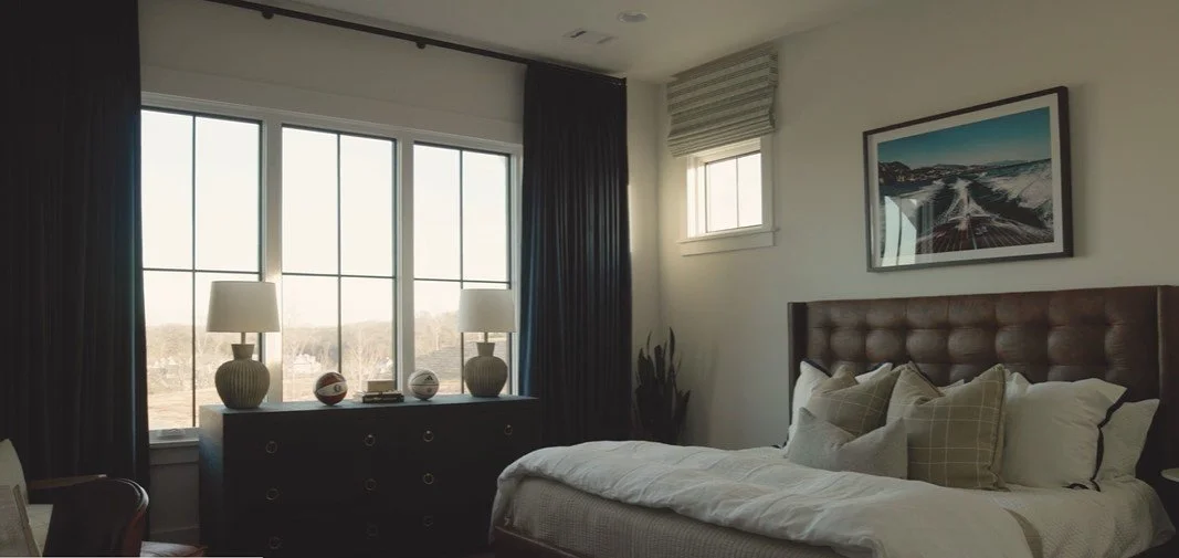 Blackout floor-to-ceiling draperies made wider than the window for full glass view and larger window appearance