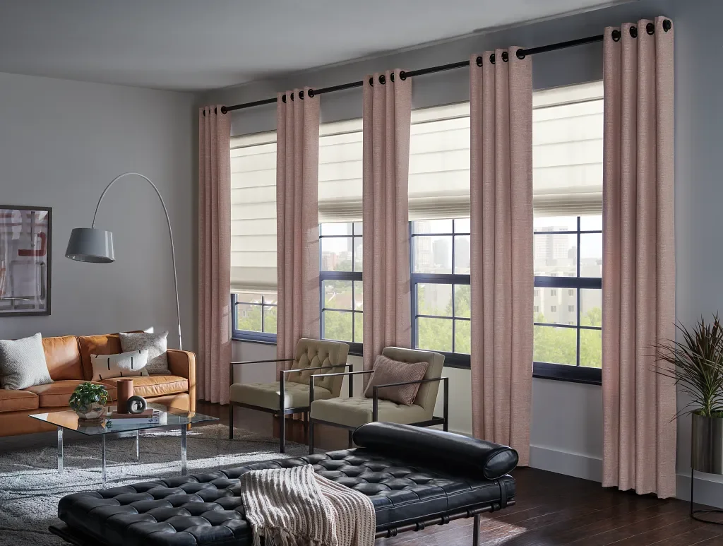 Designer Roman shades layered with decorative drapery panels