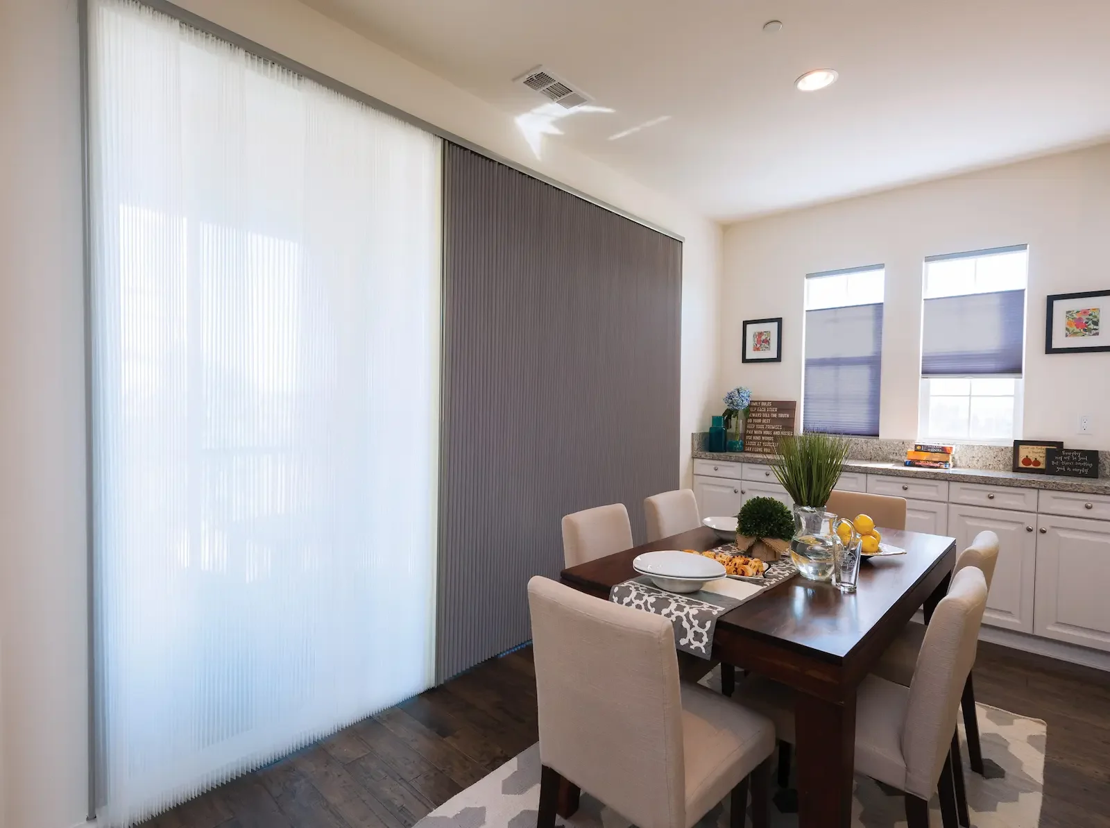 Dual vertical honeycomb shades on a sliding door paired with top down / bottom up shades on the windows