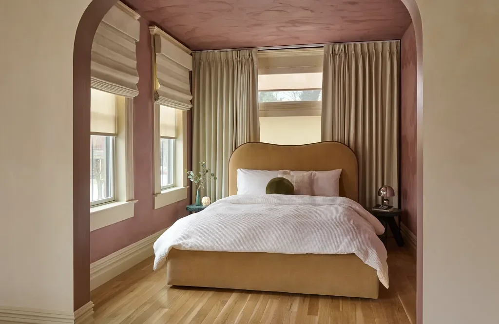 Wall-to-wall blackout draperies paired with Roman shades of the same fabric