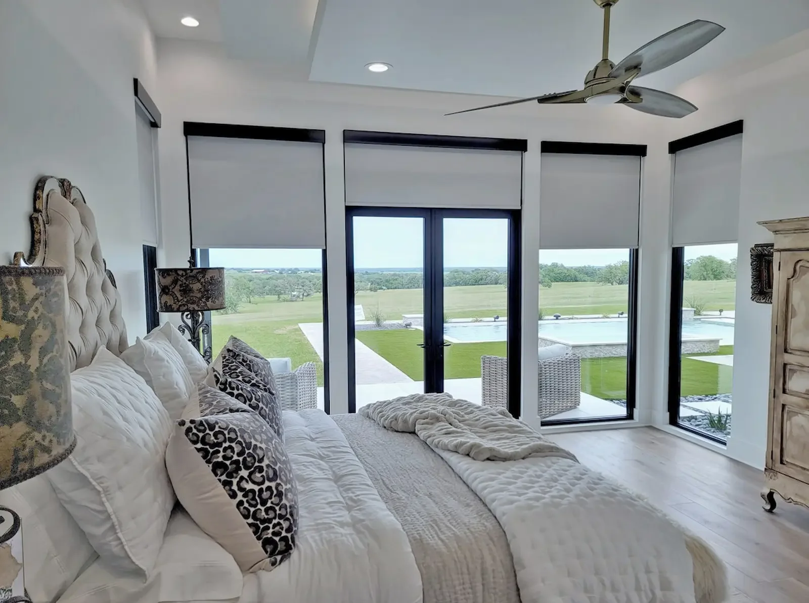 Blackout roller shades covering tall bedroom windows