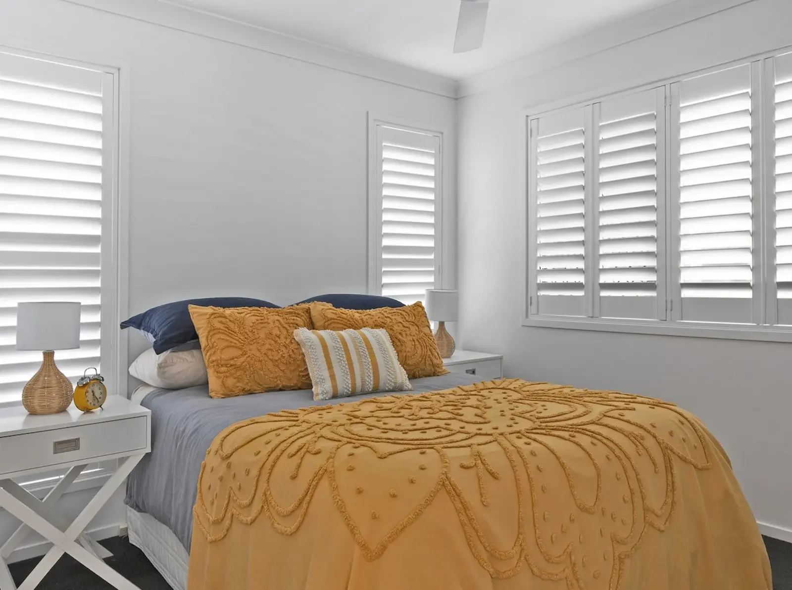 Faux wood plantation shutters add built-in character and functionality to this Nashville bedroom.