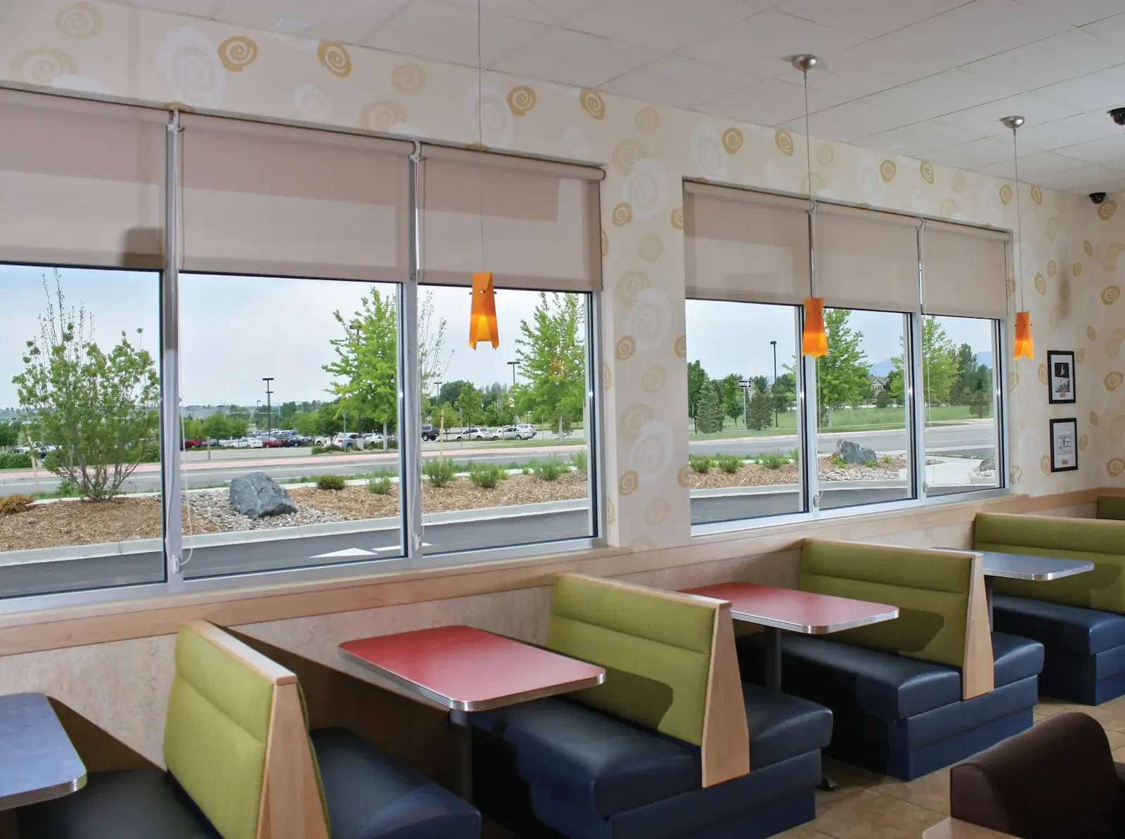 Solar roller shades installed in a restaurant with large glass panels